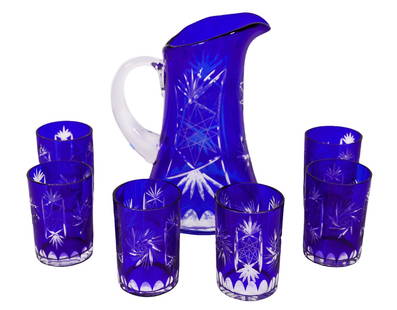 Victorian Cobalt Cut Crystal Pitcher & 6 Cups: Victorian cobalt blue cut crystal service set. To include one (1) large, handled pitcher and six (4) matching cups. Pitcher: 9-1/2” H x 6” D. Each Cup: 4” H x 2-3/4” D.