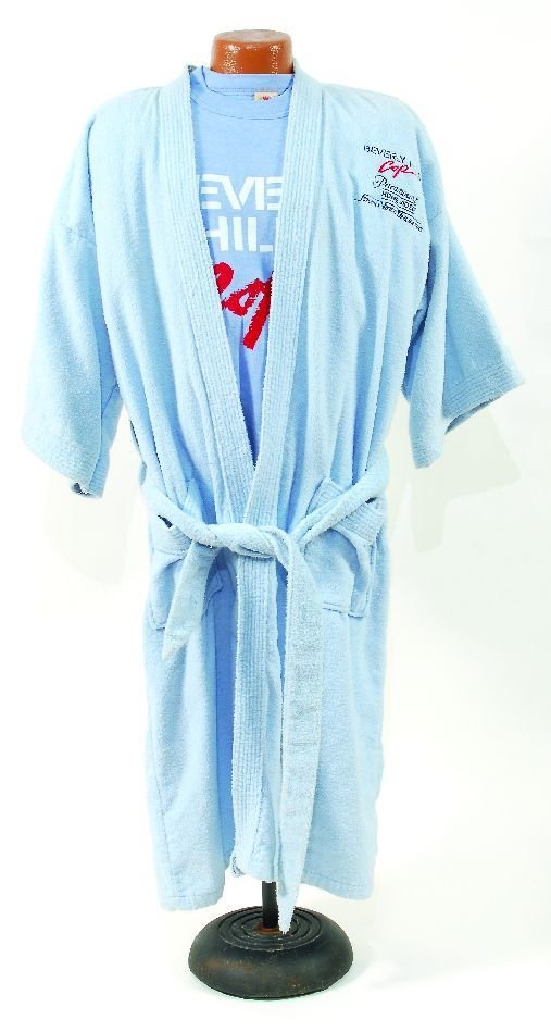 *"Beverly Hills Cop" souvenir robe prop pistol: Promotional robe created by Paramount Studios, this blue full length terrycloth robe is embroidered on the front with "Beverly Hills Cop" and "Paramount Home Video Sound Video Unlimited" together with