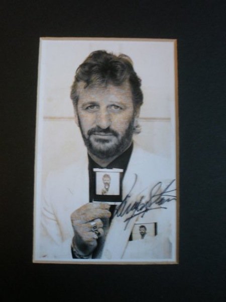 A 3.5"x5.5" original polaroid photograph of Ringo: A 3.5"x5.5" original polaroid photograph of Ringo Starr holding an Identical polaroid up to the camera with a further polaroid in his top right pocket signed boldly in black pen across th white jacket