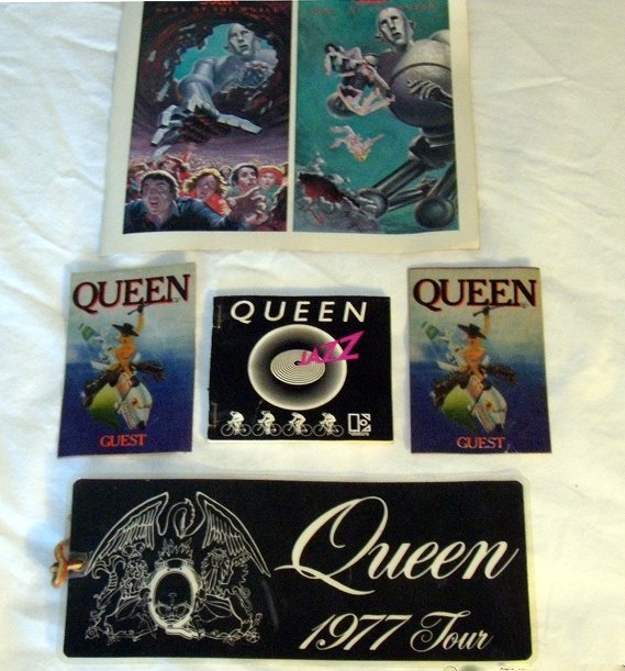 Queen Assortment of items: Queen Assortment of Queen items. Includes large band luggage tag plus various promotional items and backstage passes. PLUS Freddie Mercury’s cool purple velvet belted jacket from the movie soundtrac