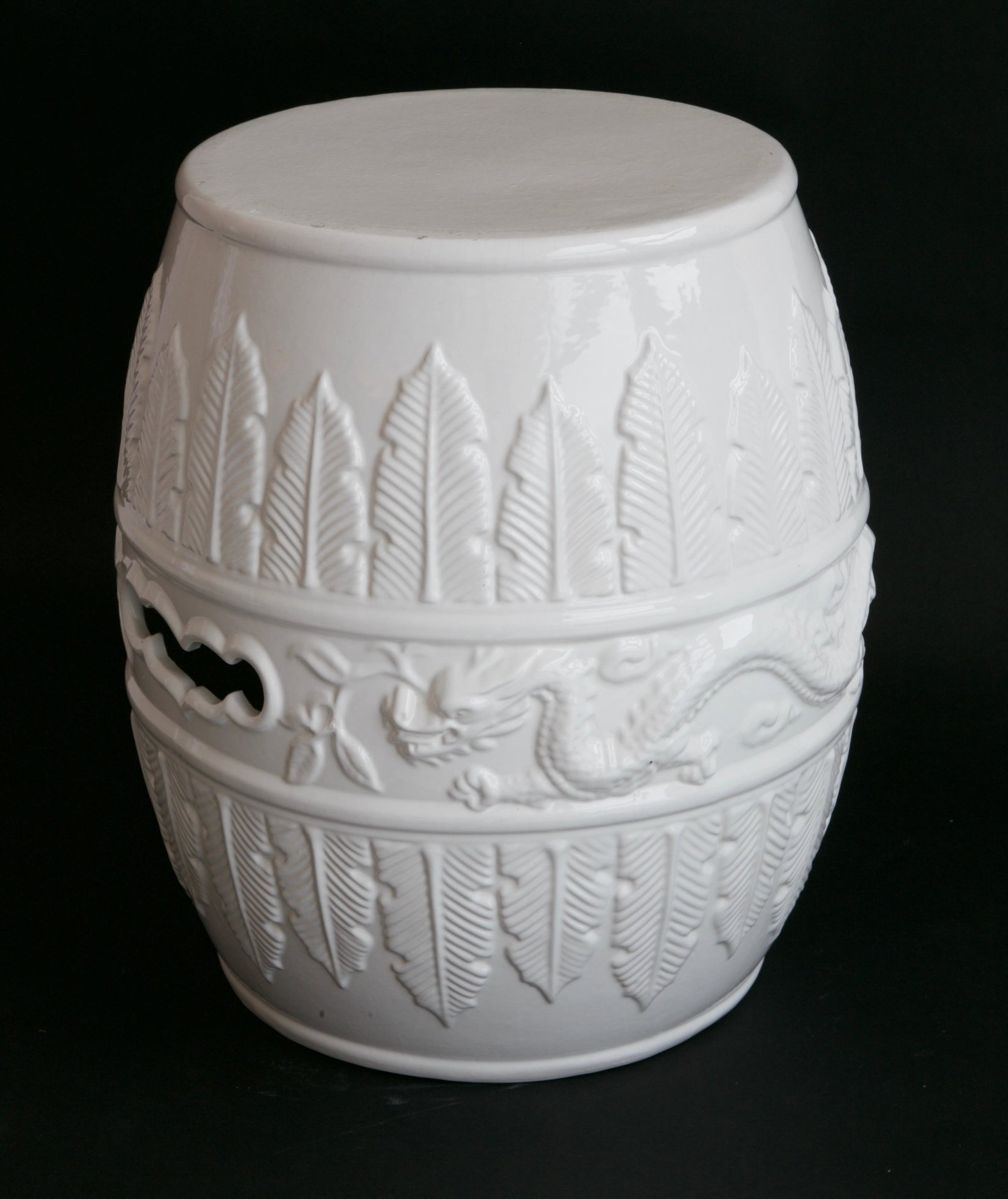 Round Embossed Blanc de Chine Garden Stool: Round Embossed Blanc de Chine Garden Stool, 20th Century, decorated with upward and downward leaves, and Chinese dragon around the mid-section Approx. Height 19 in. Diameter 11 in. Provenance: Estate 