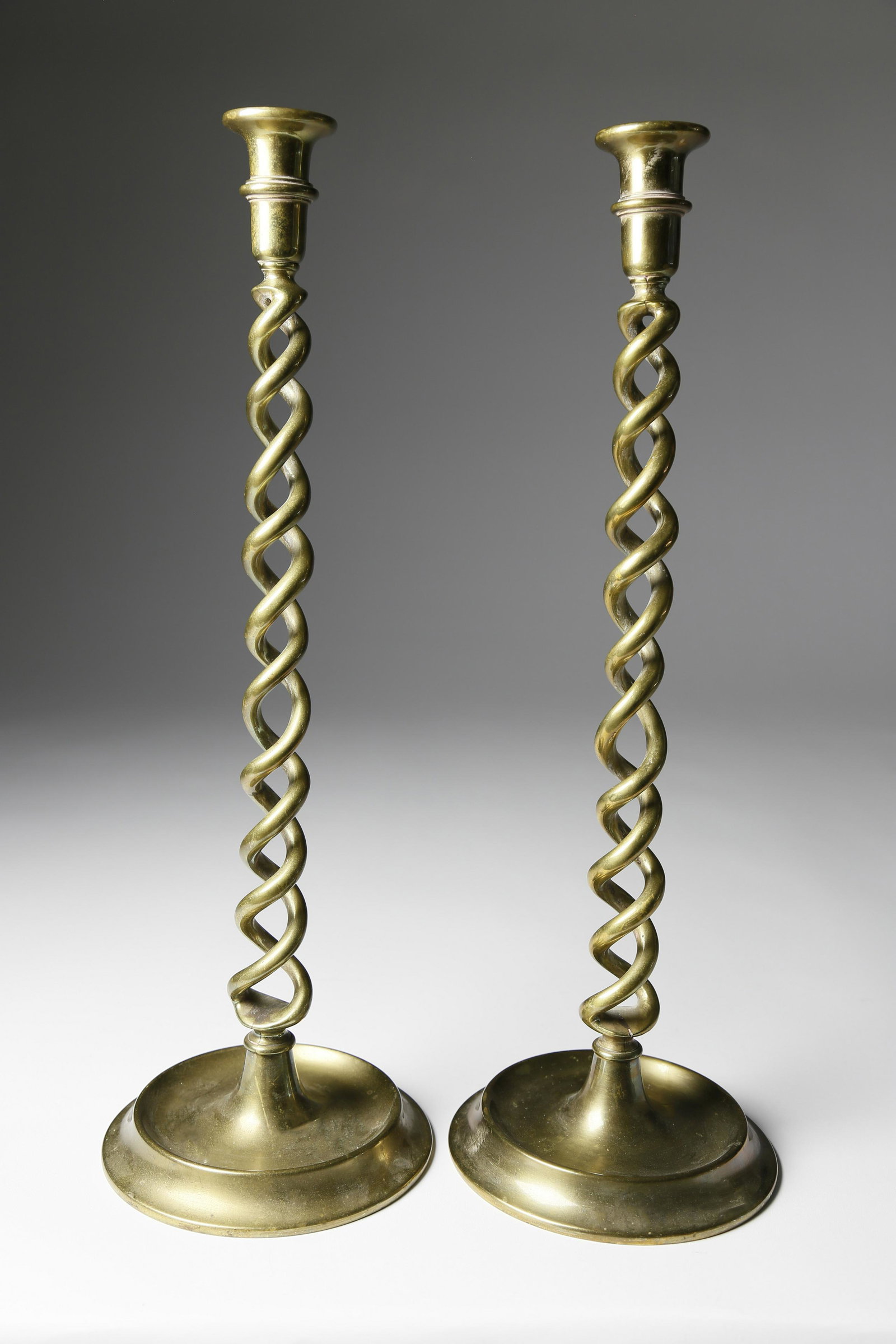 Pair of Brass Open Twist Tall Candlesticks: Pair of Brass Open Twist Tall Candlesticks, 19th century, a ringed cup above twisted brass rods emanating from a round dish base. Height 20 ¼ in.