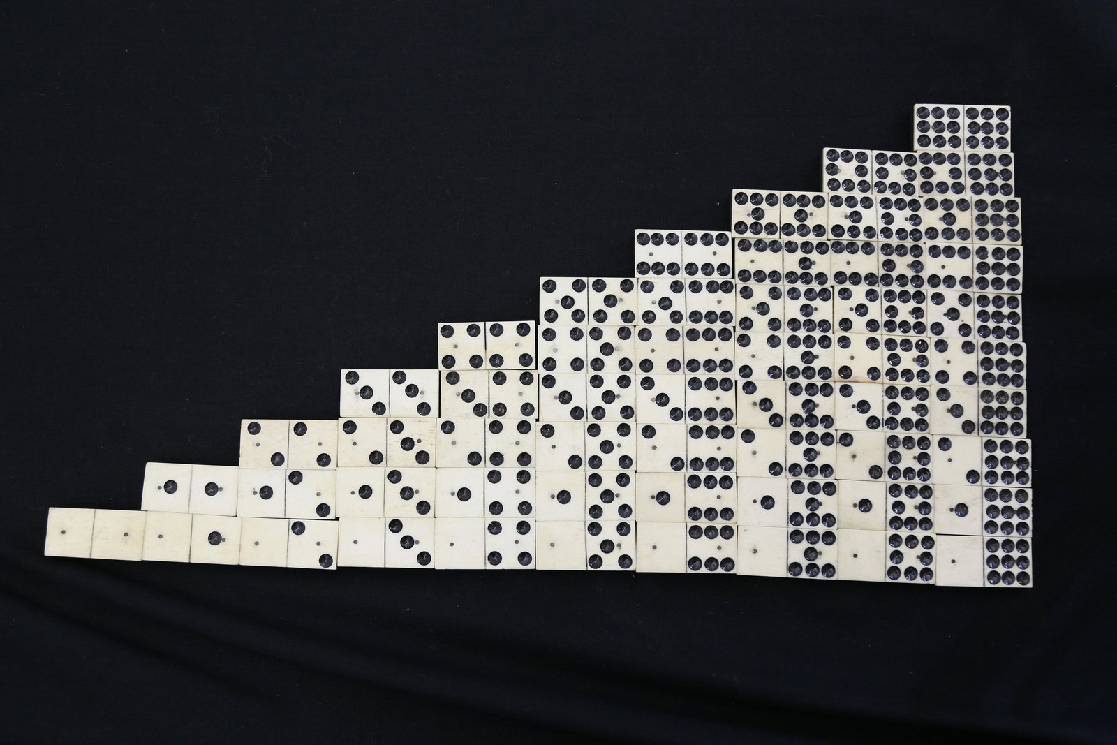 French Exhibition Bone and Ebony Double Nine Dominoes: French Exhibition Complete Set of Bone and Ebony Double Nine Dominoes, mid 19th Century, in custom dovetailed slide top box. 55 pieces Height 2 ¼ in. Width 10 ¾ in. Depth 2 ¼ in.