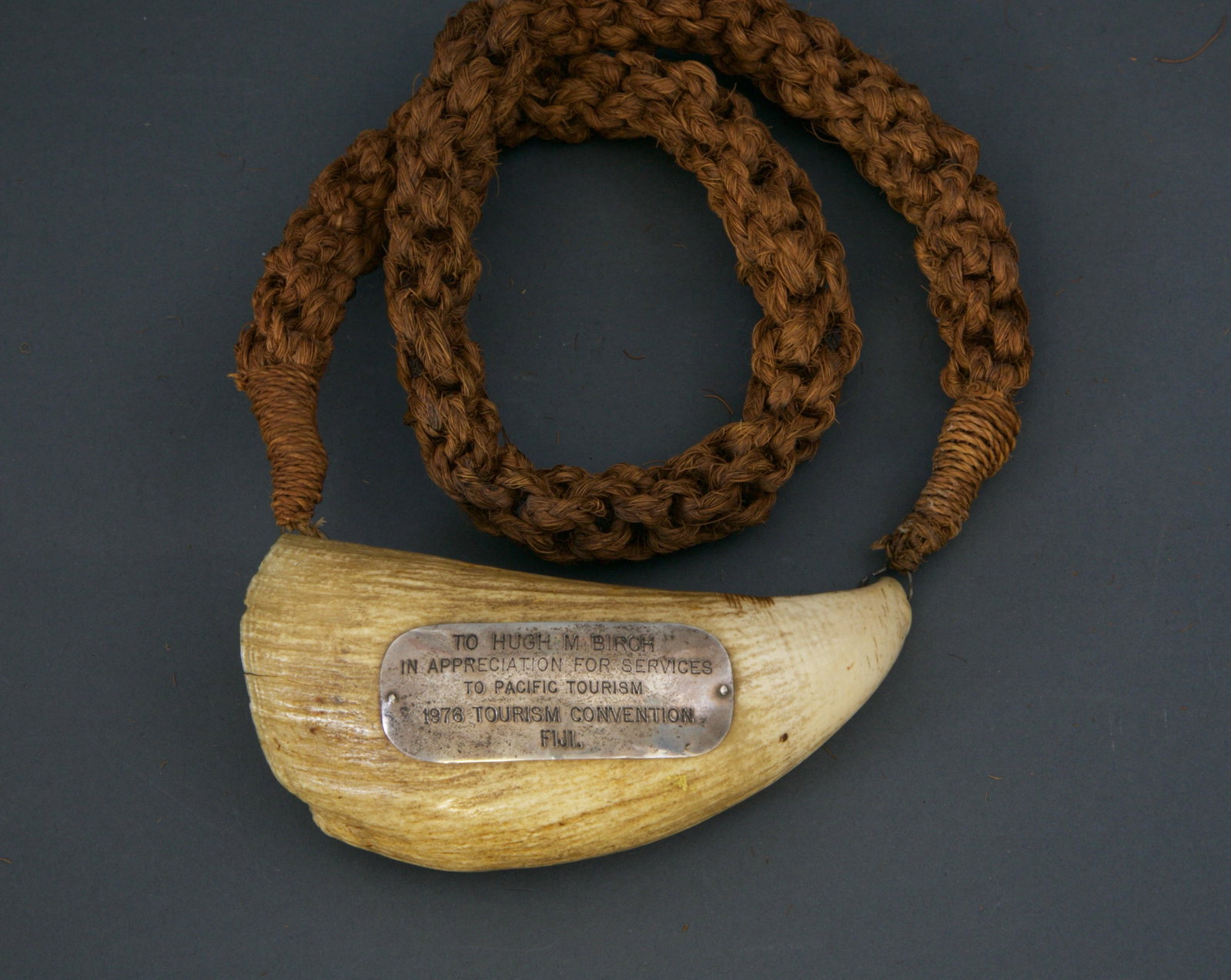 19th Century Tambua Sperm Whale Tooth: Tambua Sperm Whale Tooth, late 19th century, the necklace is woven finnet fiber, worn for ceremonies or council meetings, and applied with silver plaque inscribed “To Hugh M. Birch in Appreciation f
