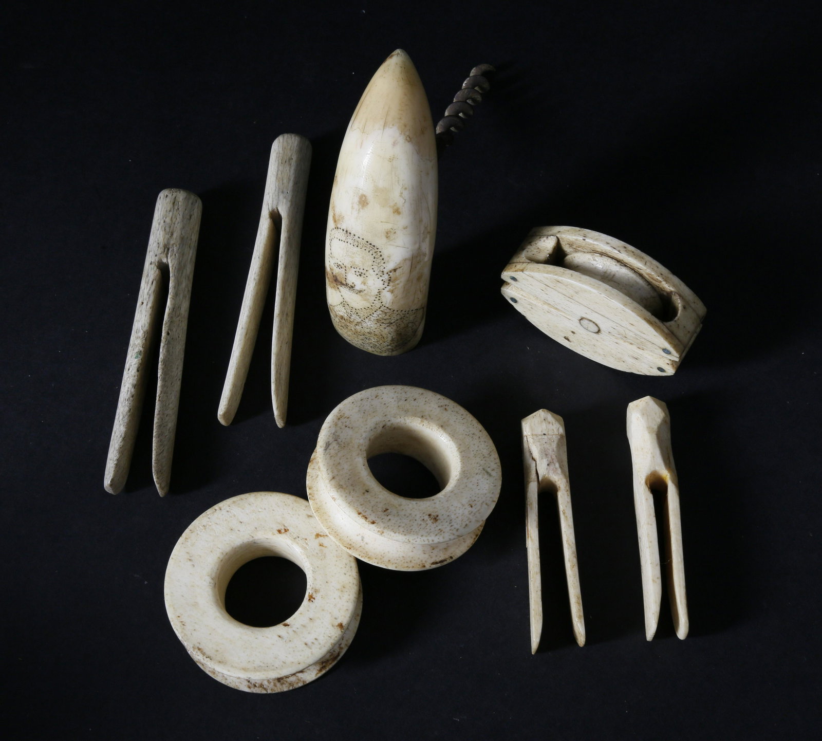 8 Whale Ivory and Whalebone Artifacts, mid 19th Century: 8 Whale Ivory and Whalebone Artifacts, mid 19th Century, comprising a scrimshawed whale tooth cork pull stippled with a portrait of a gentleman with mustache, bone block, two deadeyes and four clothes