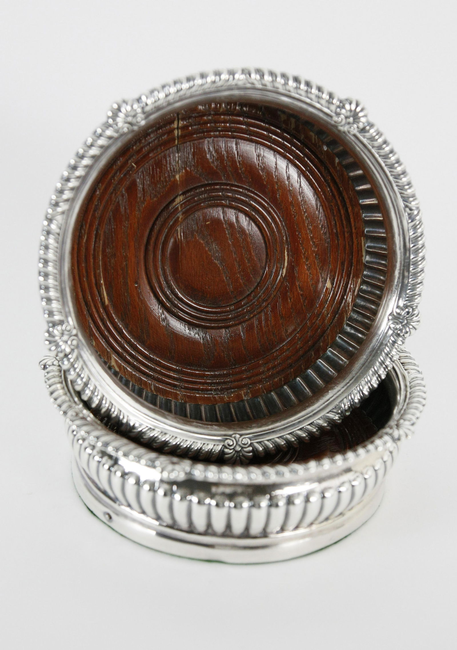 Pair of Sterling Silver Wine Coasters, 19th Century: Pair of Sterling Silver Wine Coasters, 19th Century, gadrooned and shell decorated rim, with turned wooden base. Height 2 in. Diameter 6 ½ in.
