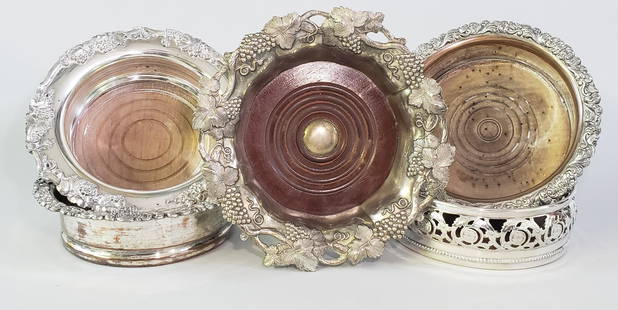 Set of 5 Antique Silver Plated Wine Coasters: Set of 5 Antique Silver Plated Wine Coasters, with pierced, floral, gadrooned, and stippled decoration all with turned wooden base. Height 2 in. Diameter 7 in. to 5.5 in. Provenance: Estate of
