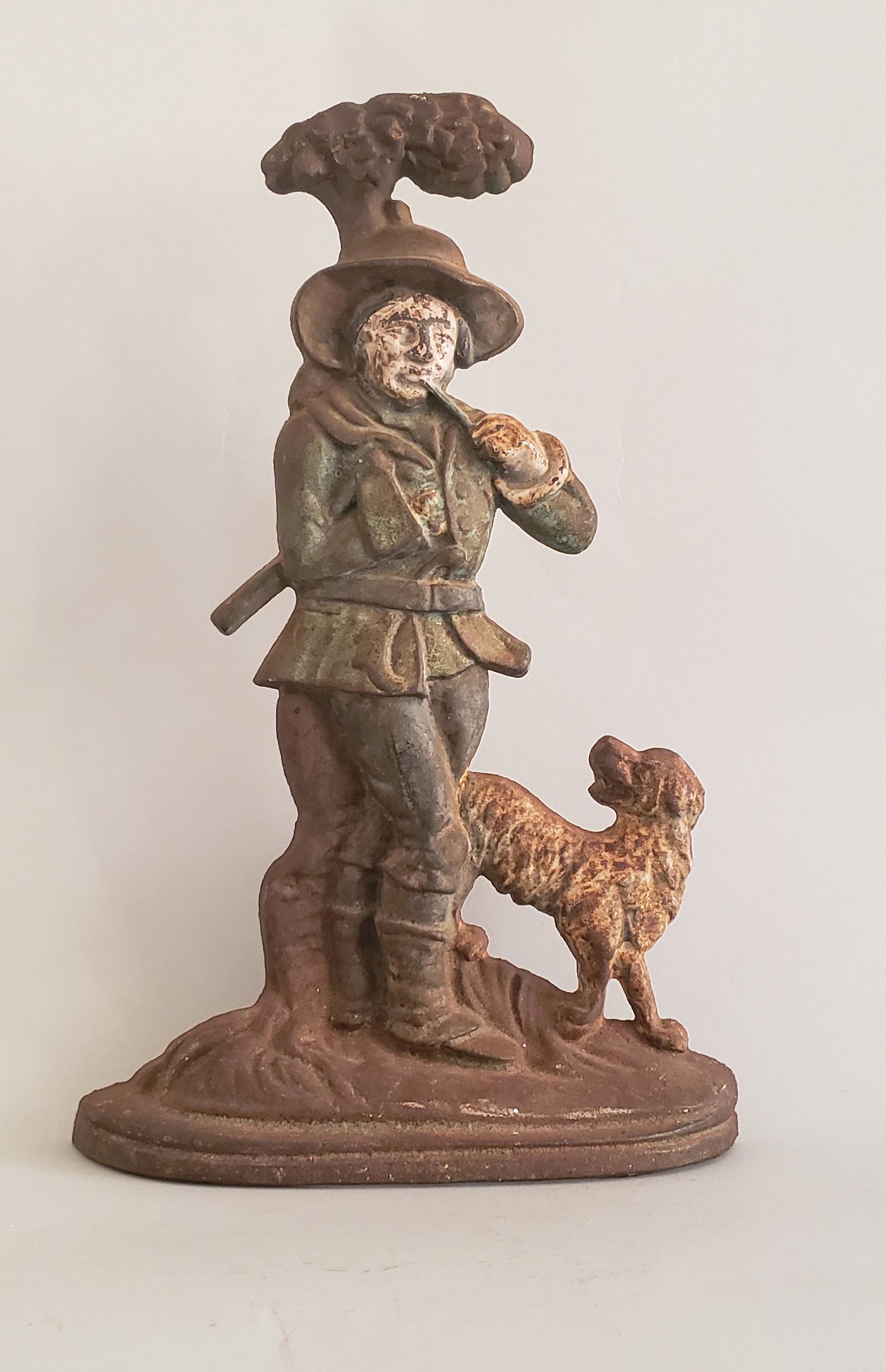 Antique Cast Iron Figural Hunter Doorstop: Antique Cast Iron Figural Hunter Doorstop, depicting a gentleman walking through the woods while smoking his pipe with his dog. Height 14 in. Width 9 in. Depth 2 in. Dimensions Height 14 in. Width 9 i
