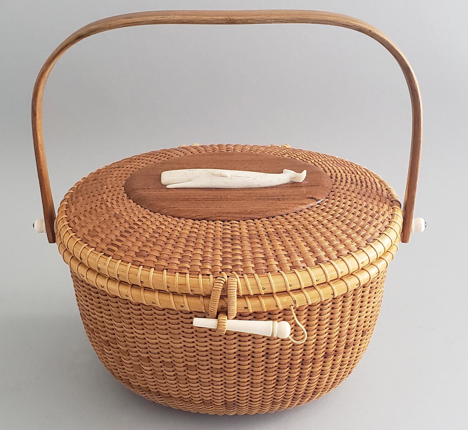 Bill and Judy Sayle Oval Nantucket Friendship Basket: Bill and Judy Sayle Oval Nantucket Friendship Basket, a day purse with carved whalebone sperm whale ornament, signed upon the base, "B & J Sayle, 1980" Height 6.5 in. Width 9.25 in. Depth 7.5 in. Heig