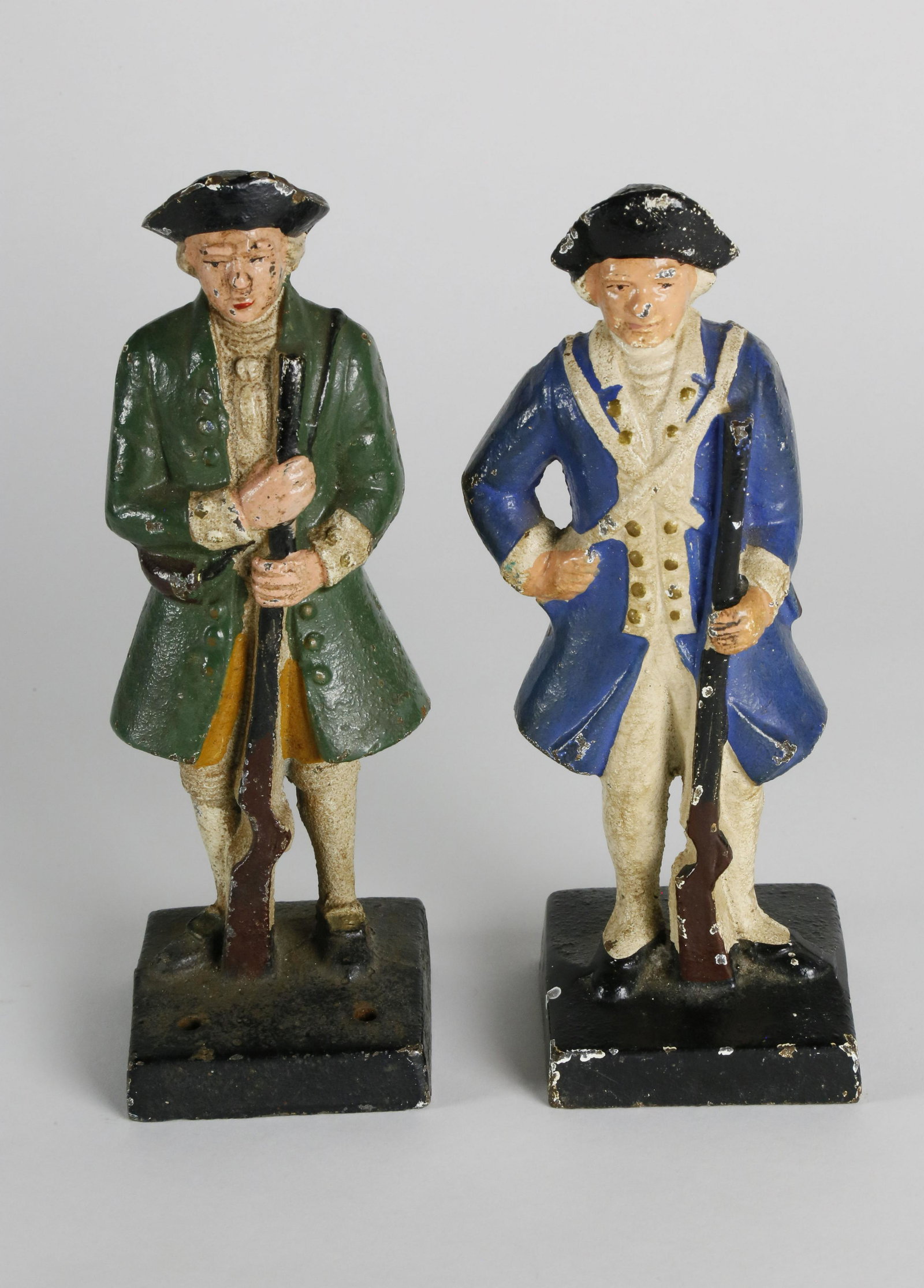 Two Cast Iron Hand Painted Colonial Minute Man: Two Cast Iron Hand Painted Colonial Minute Man Doorstops, one in green coat and one in blue coat Height 7 in.