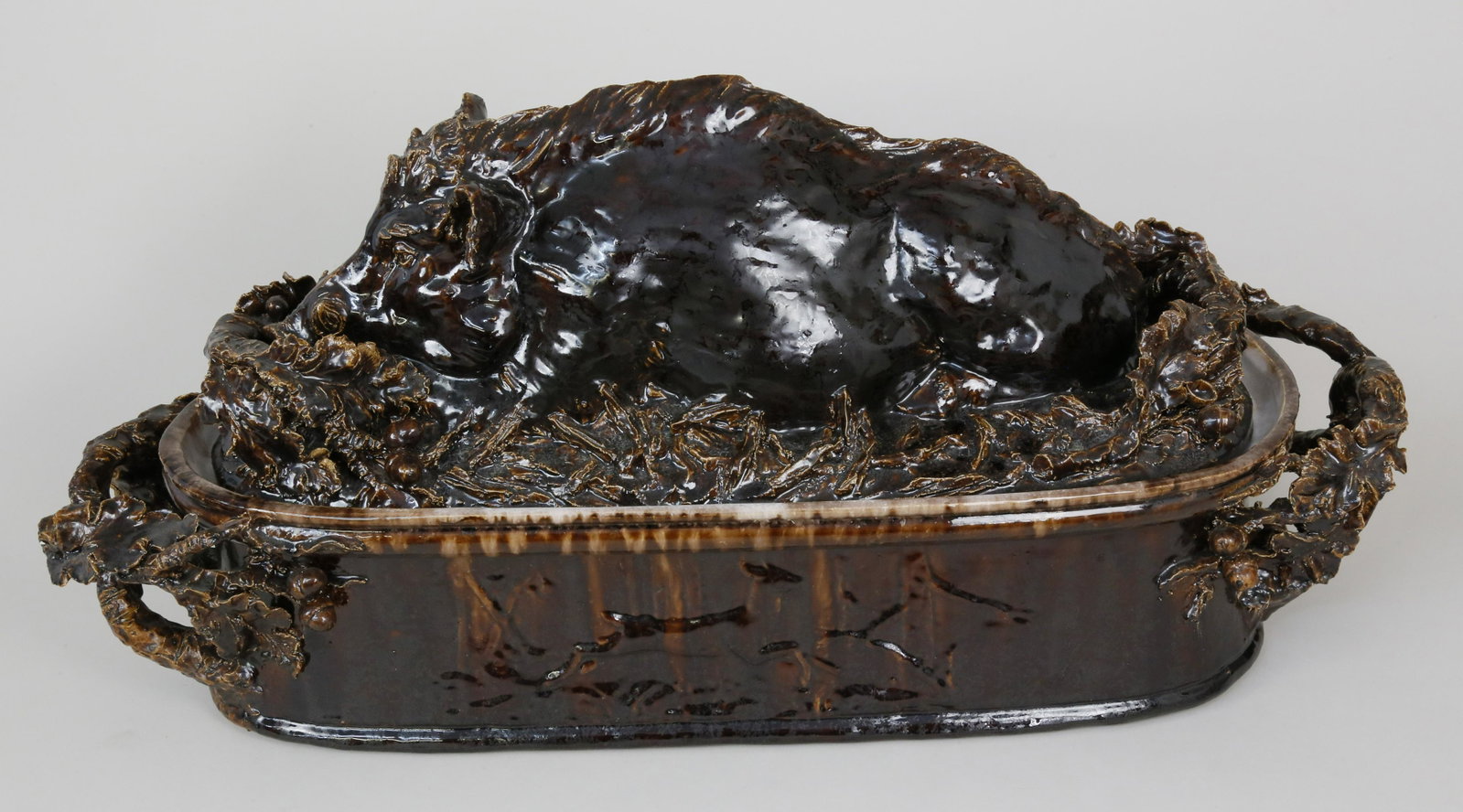 Jean Paul Gourdon Brown-glazed Sanglier Terrine: Jean Paul Gourdon (French b. 1956) Brown-glazed Sanglier Terrine, the tapered elliptical earthenware vessel hand-modelled with recumbent wild boar surrounded by fruiting oak; the handles formed as ent