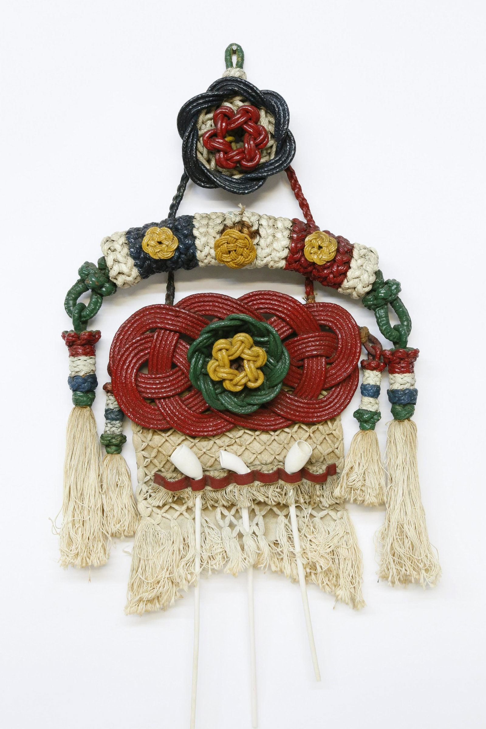 Large Sailor Made Macrame Pipe/Utensil Holder, 19th c.: Large Sailor Made Macrame Pipe/Utensil Holder, late 19th Century, a robust rendition of varying knot designs on a hanging holder and painted wreaths, mat, bumper and tassels. 32 in. x 20 in.