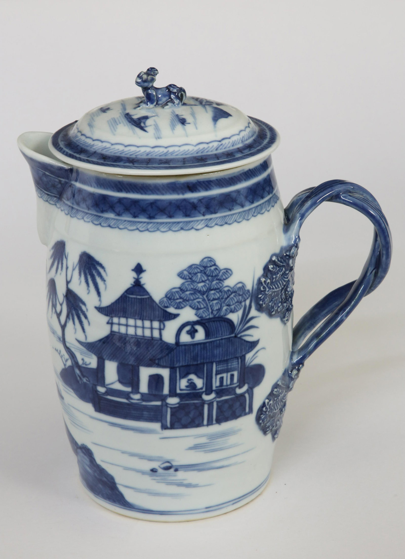 Canton Cider Jug, late 18th Century: Canton Cider Jug, late 18th Century, attenuated barrel form, rib-molded collar, interlaced reeded handle ending in plume, dome cover with foo dog finial, allover Canton river landscape scenes. Height 