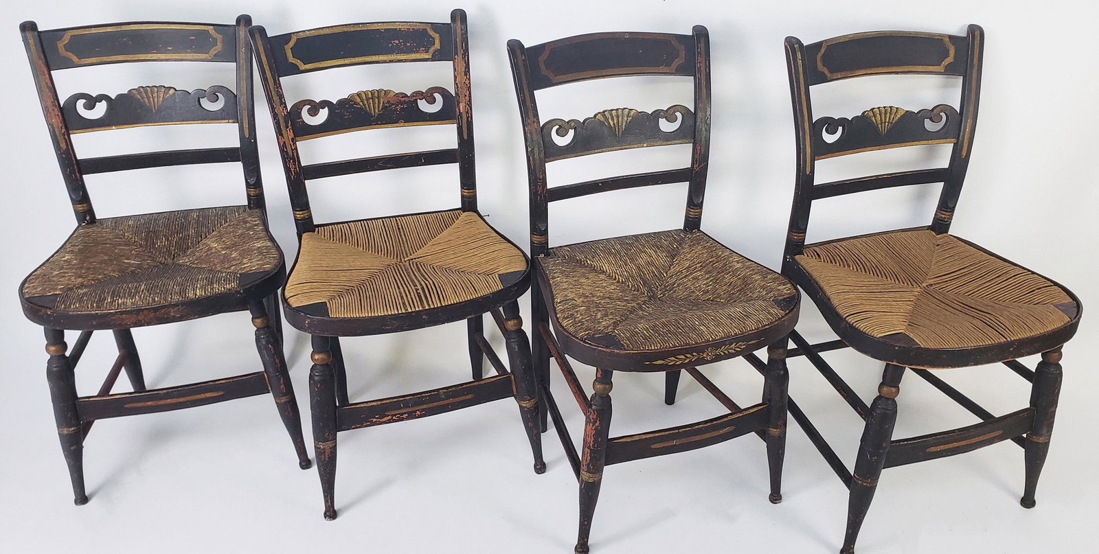 Set of Four Antique Rush Seat Hitchcock Dining Chairs, 19th Century: Set of Four Antique Rush Seat Hitchcock Dining Chairs, 19th Century, with carved and gilt decorated shell backsplash. Two seats replaced. Height 33.75 in. Width 18 in. Depth 18.25 in. Seat Height 17.