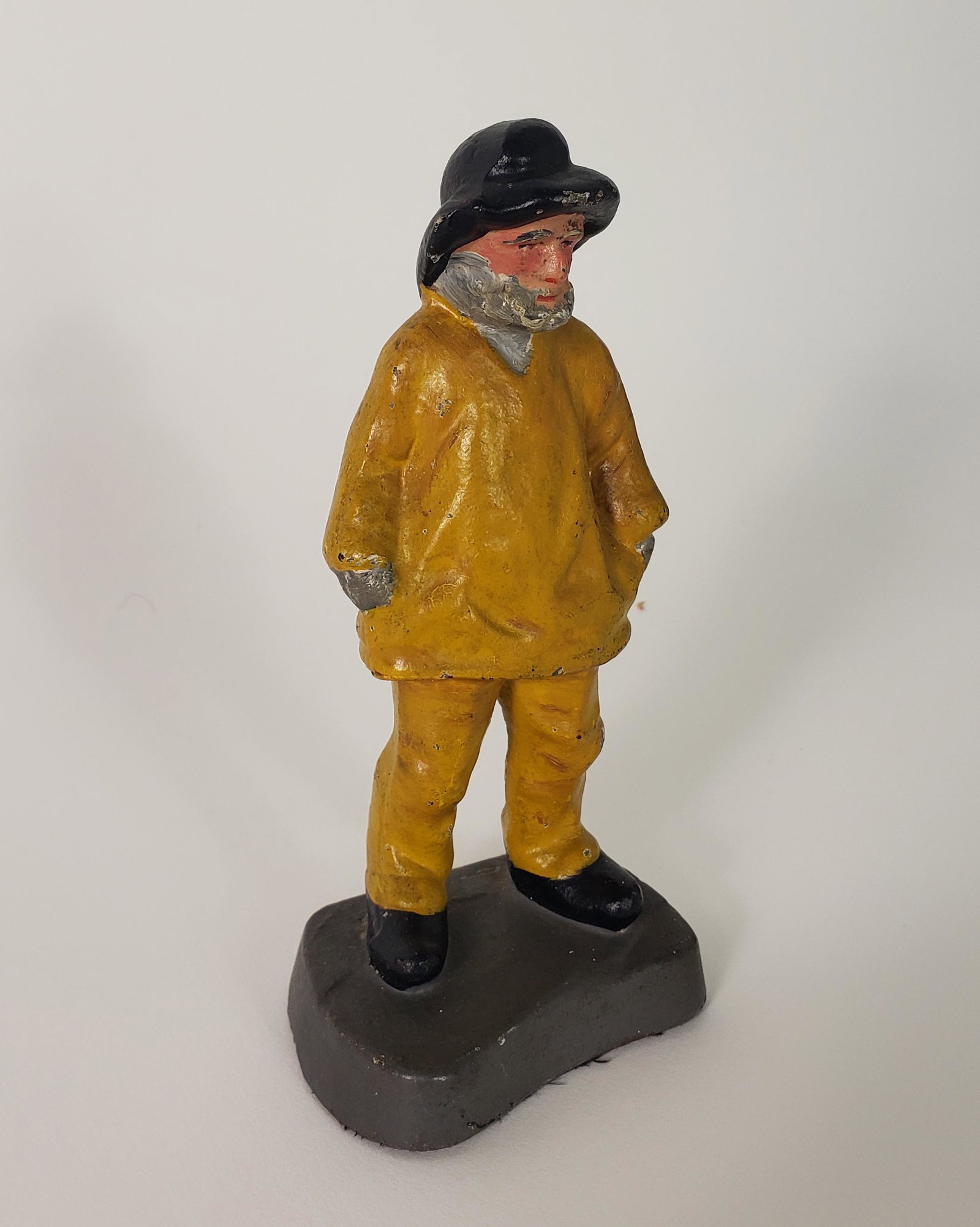 Antique Figural Cast Iron Old Salt Fisherman Doorstop: Antique Figural Cast Iron Old Salt Fisherman Doorstop, depicted with the fisherman's hands tucked into his anorak jacket. Height 5.5 in. Width 2.5 in. Depth 2 in.