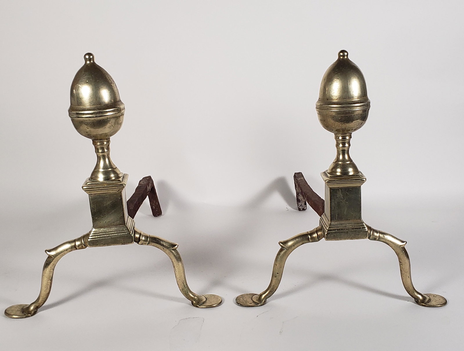 Pair of Antique Brass Philadelphia Acorn and Finial Andirons, circa 1800: Pair of Antique Brass Philadelphia Acorn and Finial Andirons, circa 1800, on arched legs and penny feet. Height 15.5 in. Width 13 in. Depth 21.75 in.