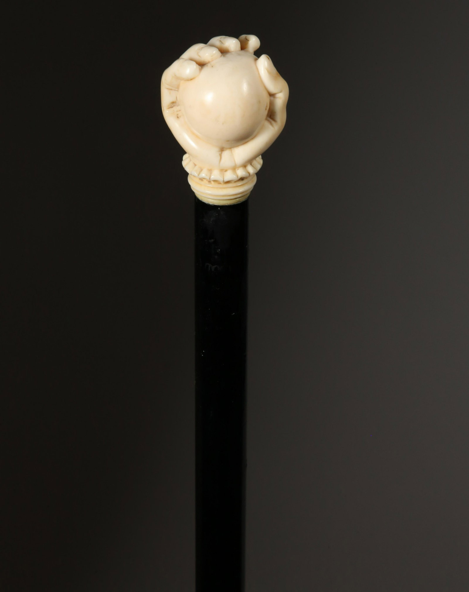 Whaleman Made Hand Grasping Ball Walking Stick, circa 1860: Whaleman Made Hand Grasping Ball Walking Stick, circa 1860, carved antique whale ivory hand grasping a ball grip, with ruffled shirt cuff on an ebony shaft ending in a horn ferrule Length 35 in. Prove