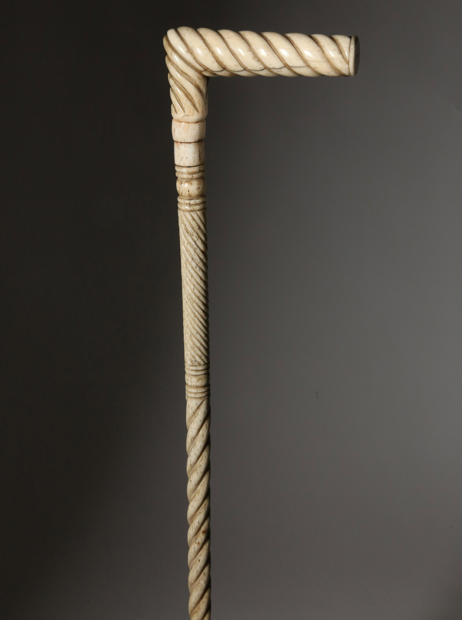 Whaleman Made Antique Whalebone L-Grip Cane, circa 1860s: Whaleman Made Antique Whalebone Cane, circa 1860s, twist carved L-grip on a multi-twist and ring carved whalebone shaft Length 37.25 in. Provenance: The Estate of Stephen Weinroth, Nantucket, Massachu