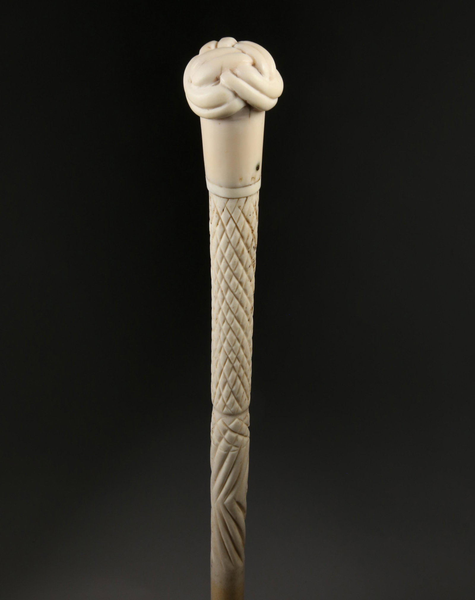 Whaleman Made Turk's Knot Walking Stick, circa 1860: Whaleman Made Turk's Knot Walking Stick, circa 1860, carved antique whale ivory Turk's knot on a cross-hatch carved and tapering whalebone shaft, ending in a black ferrule Length 35.5 in.Provenance: T