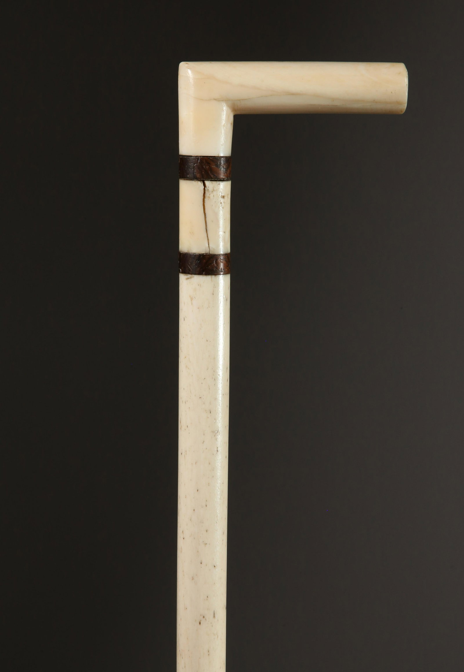 Whaleman Made L-Grip Cane, 19th Century: Whaleman Made L-Grip Cane, 19th Century, turned antique whale ivory L-grip above three ebony and ivory spacers upon a turned and tapered whalebone shaft Length 33 in. Provenance: The Estate of Stephen