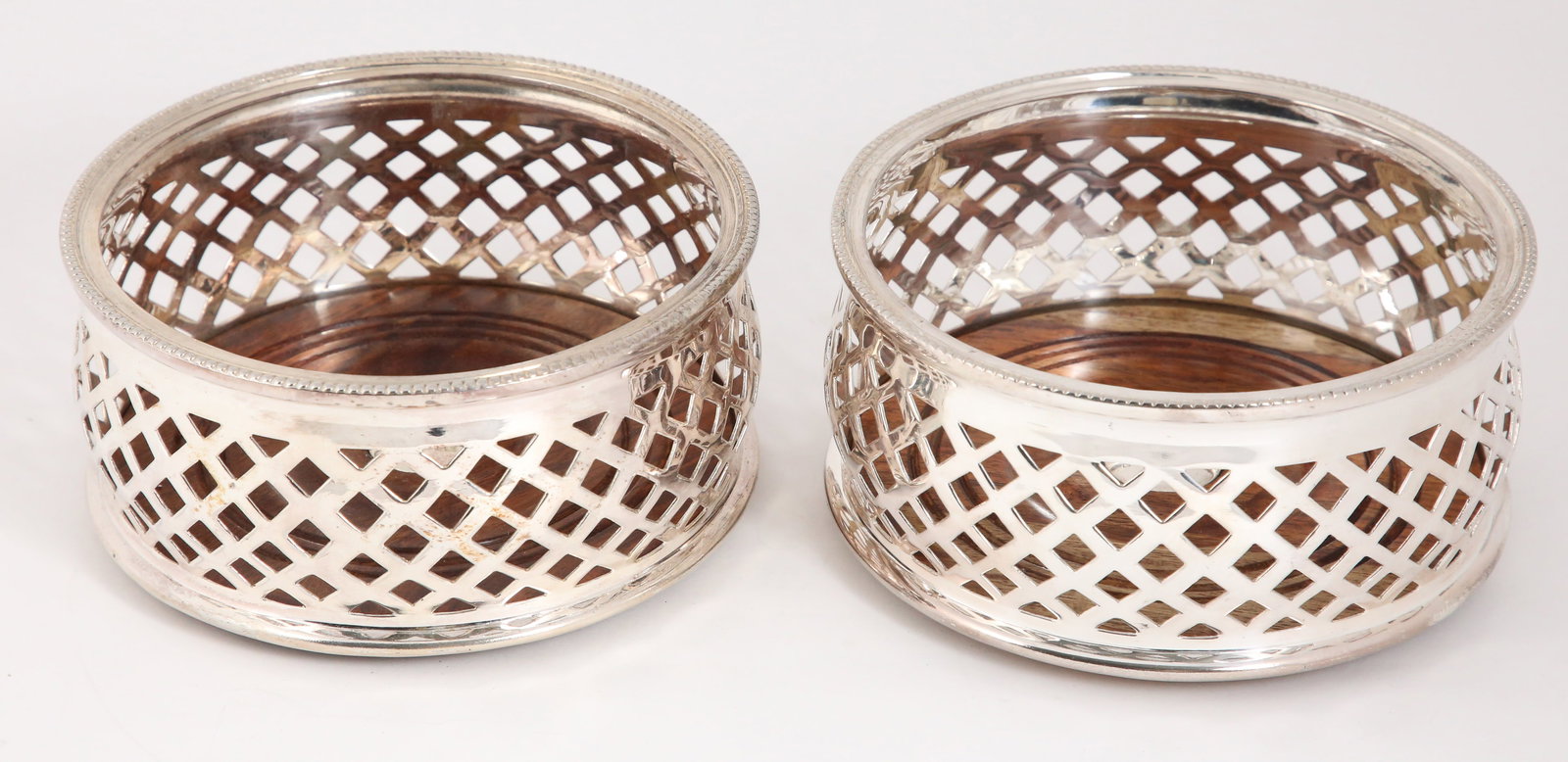 Pair of Sheffield Silver Plated Wine Coasters: Pair of Sheffield Silver Plated Wine Coasters, Contemporary, turned wood bases stamped "Royal Castle Sheffield" Height 2.5 in. Diameter 5.5 in.