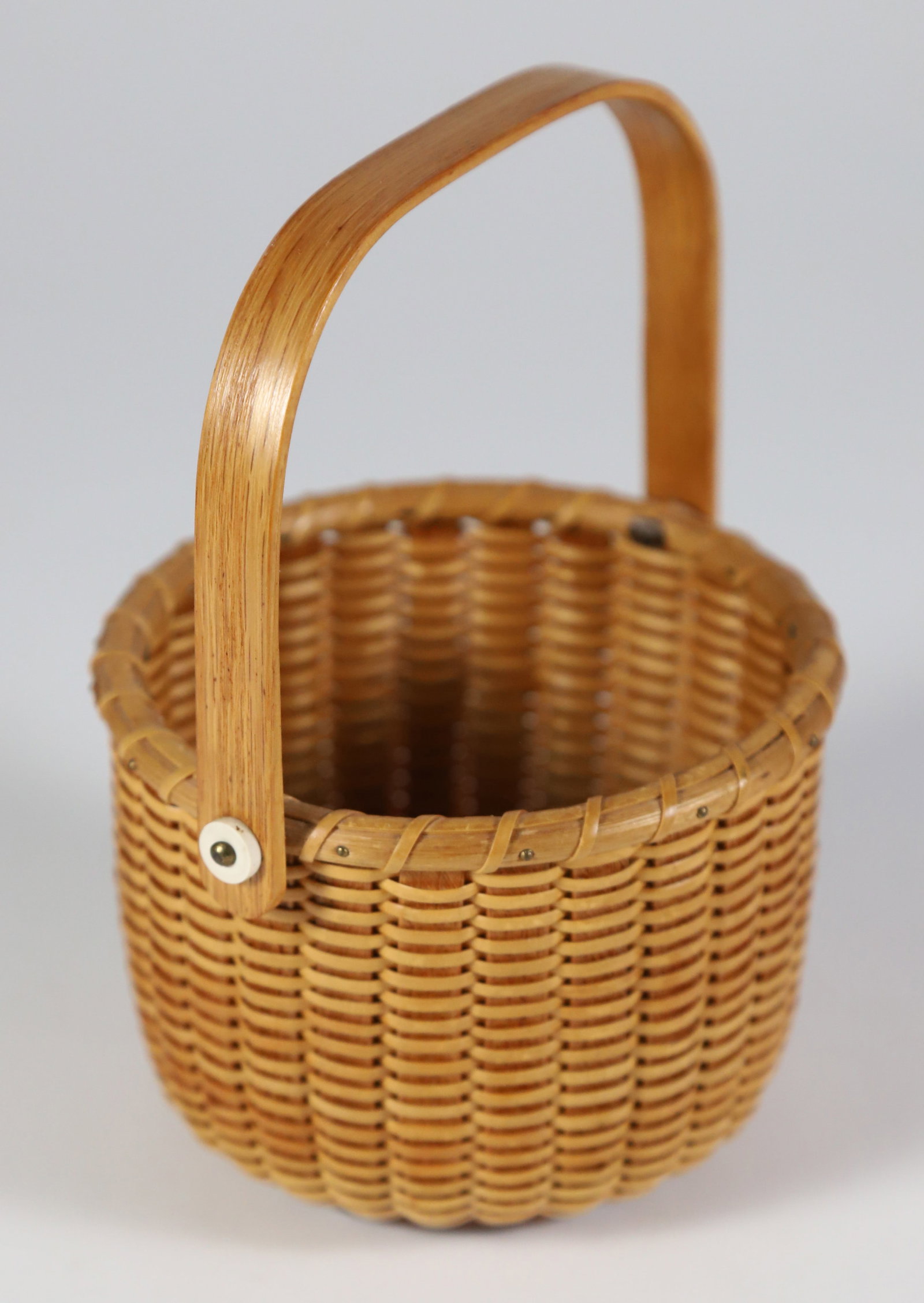 B. & I. Round Open Swing Handle Nantucket Basket: B. & I. Round Open Swing Handle Nantucket Basket, signed on base B. & I. Nantucket Height 3 in. Diameter 4.5 in.