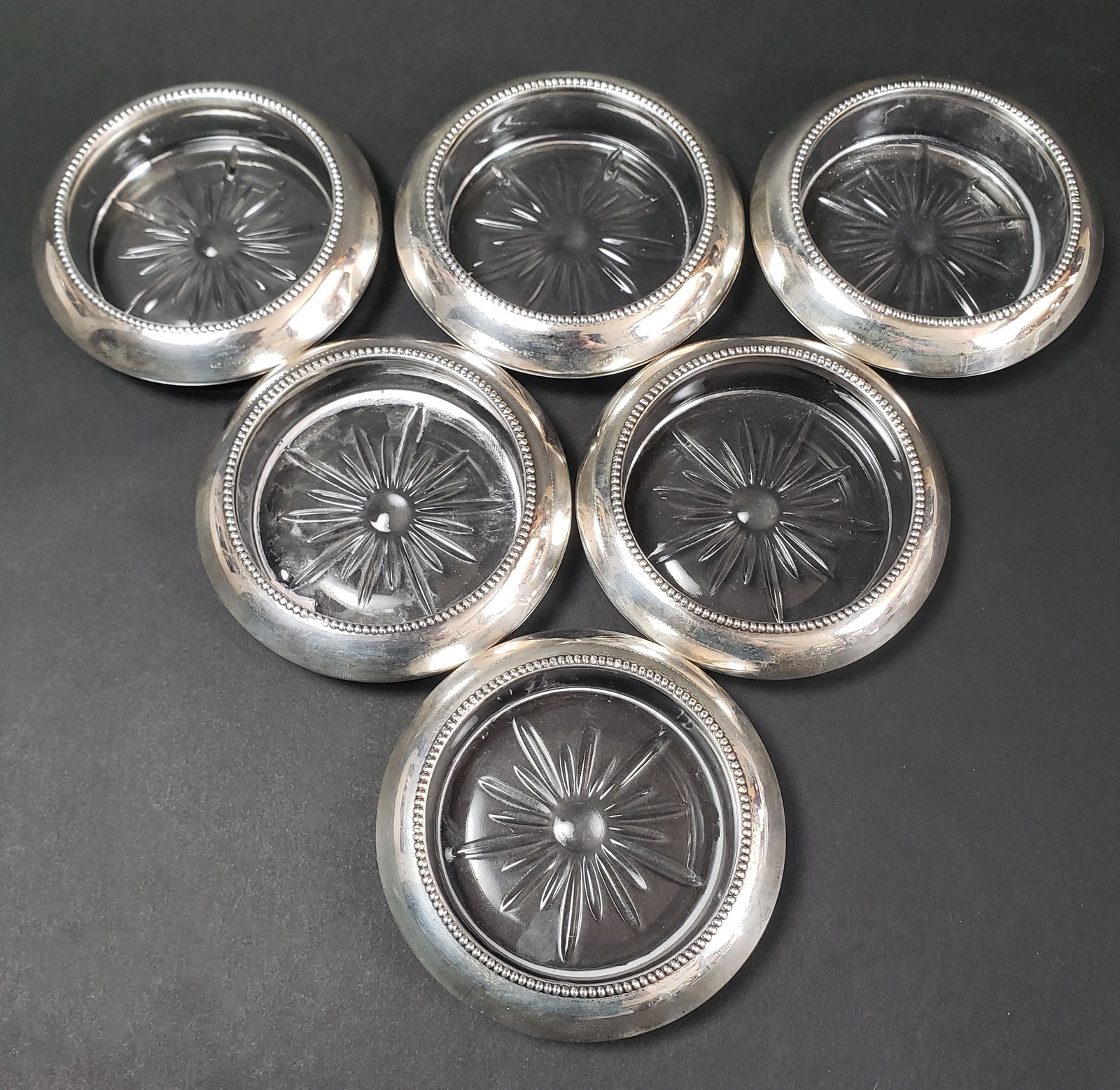 Group of Six Frank M Whiting & Co Sterling Silver and Crystal Wine Coasters: Group of Six Frank M. Whiting & Co. Sterling Silver and Crystal Wine Coasters, each coaster stamped,Sterling, on the band with gadrooned edges and cut clear crystal bases. Diameter 4 in.