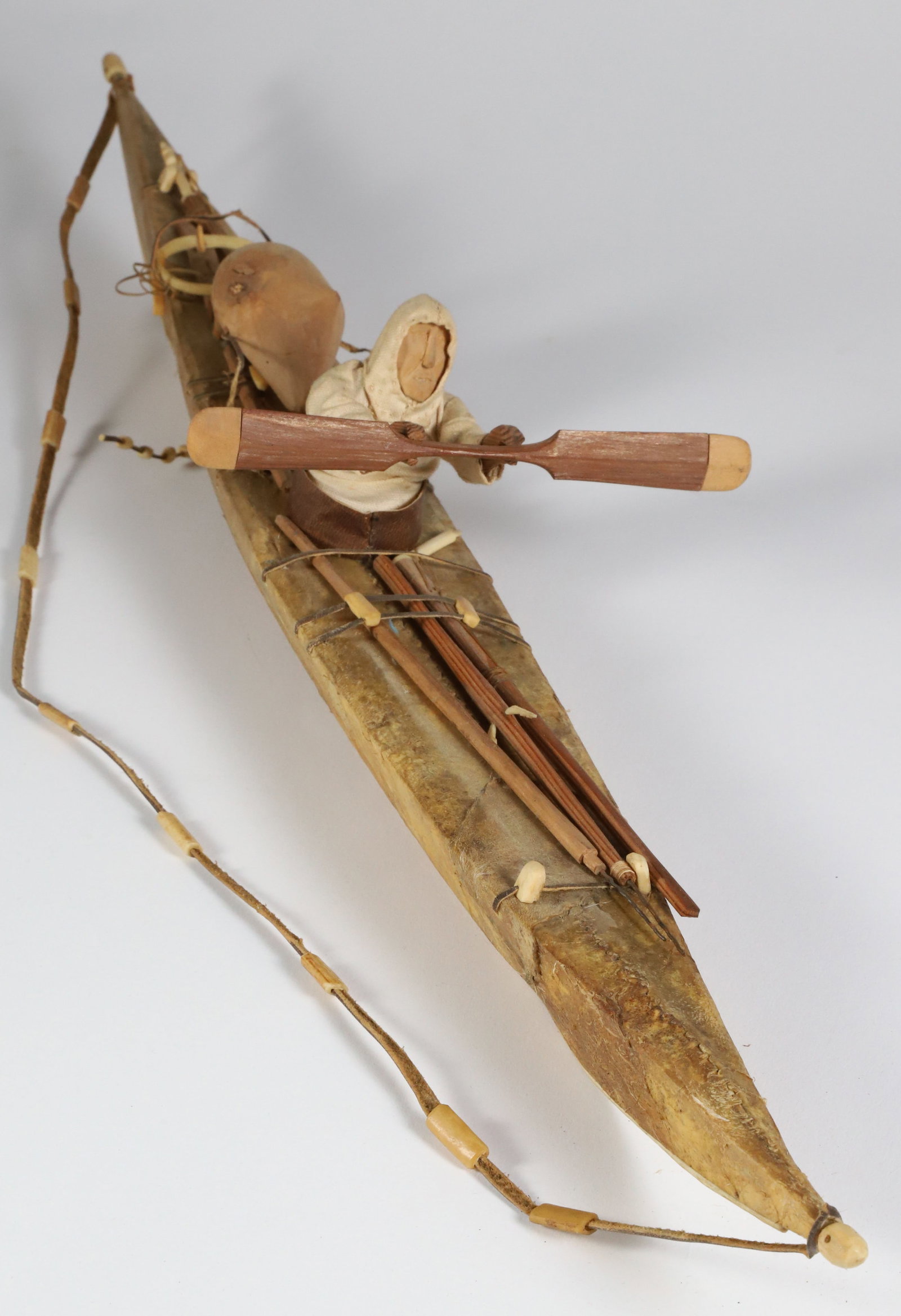 Vintage Model of an Eskimo Inuit Kayak, circa 1900-1920: Vintage Model of an Eskimo Inuit Kayak, circa 1900-1920, including hunter with double blade paddle, harpoons, full implements and equipment; made of seal skin, wood, leather, bone, sinew and textile H
