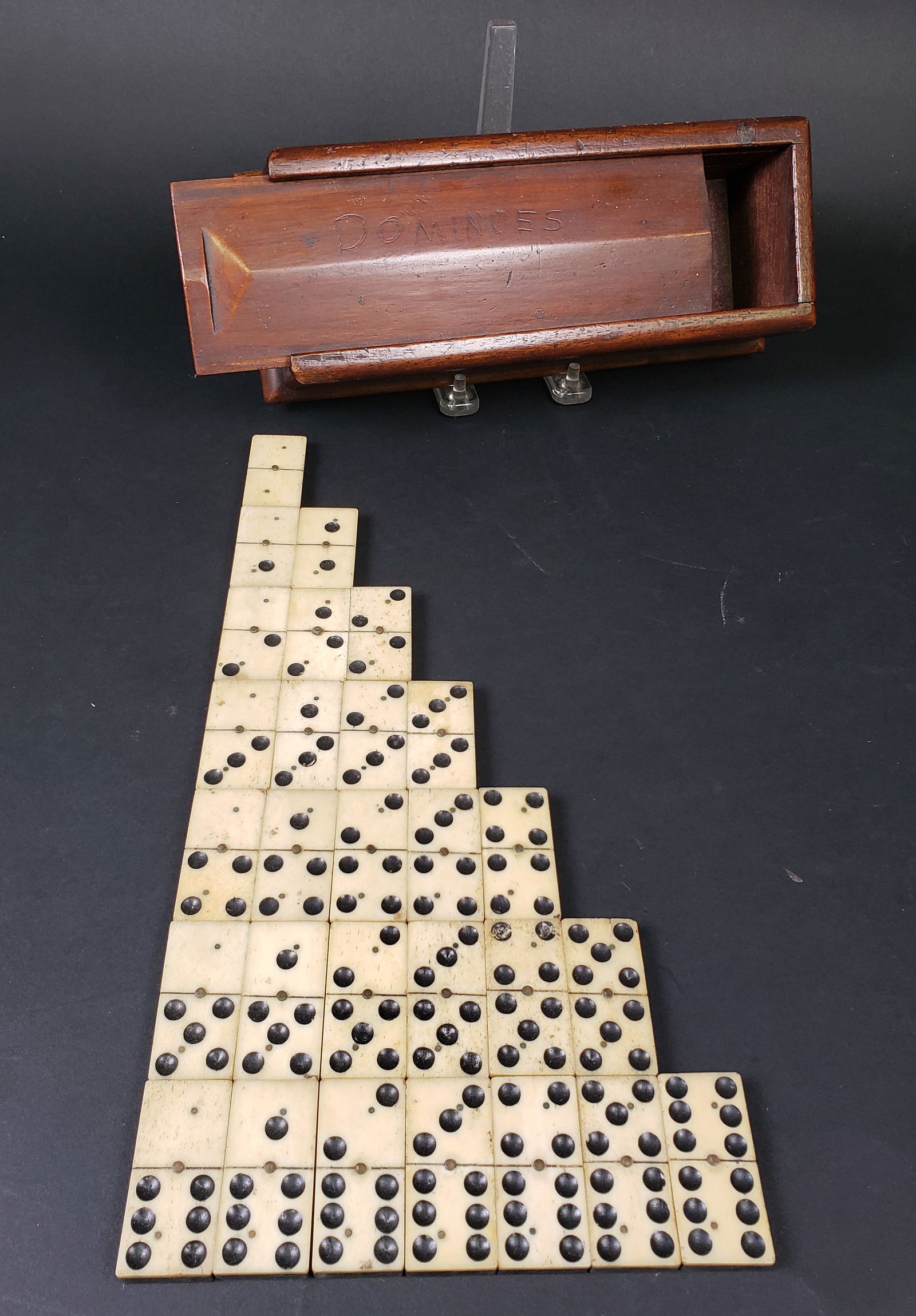 Complete Set of Antique Sailor Made Bone and Ebony Dominoes, 19th century: Complete Set of Antique Sailor Made Bone and Ebony Dominoes, 19th century housed in a slide top mahogany box, 28 tiles. Box Height 3 in. Width 4 in. Depth 10 in. Tile 2 in. x 1 in.