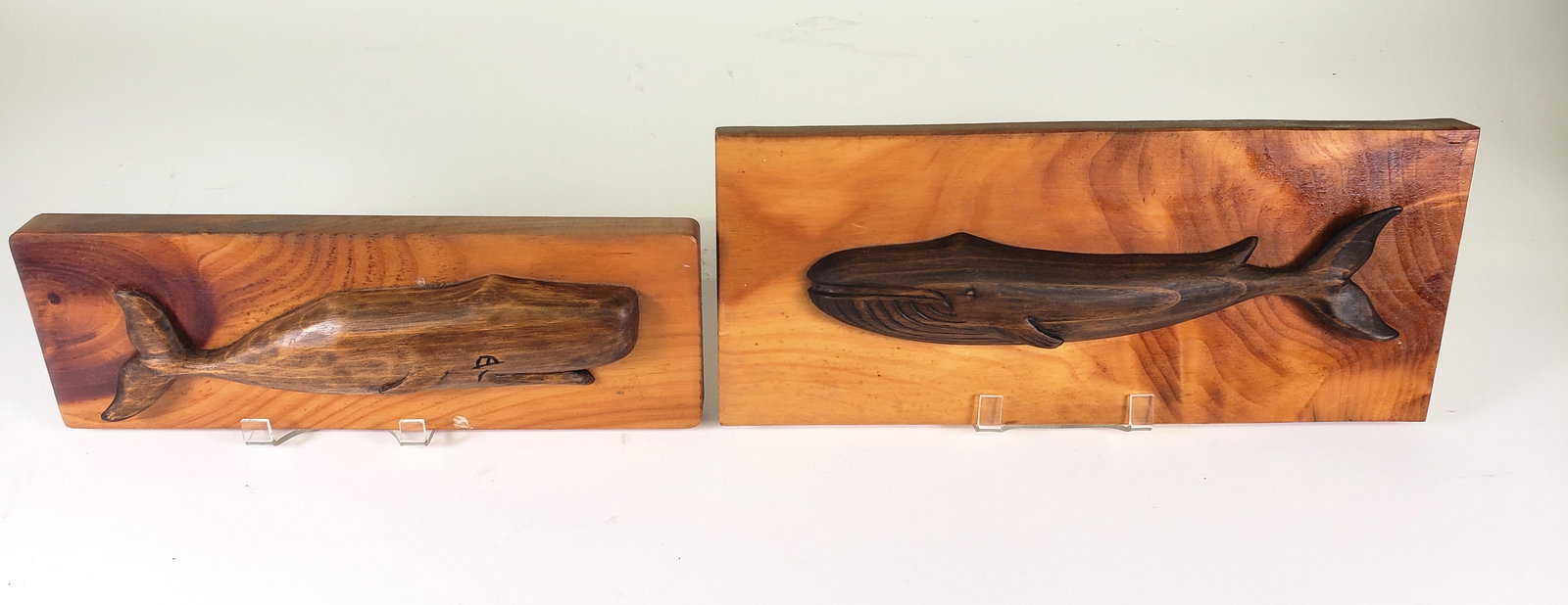 Two Roger N Andrews Carved Whale Plaques, 20th century: Two Roger N Andrews Carved Whale Plaques, 20th century, The Jolly Roger Sperm Whale and Humpback Whale. 4.5 in. x 12.75 in. and 6 in. x 14.5 in.