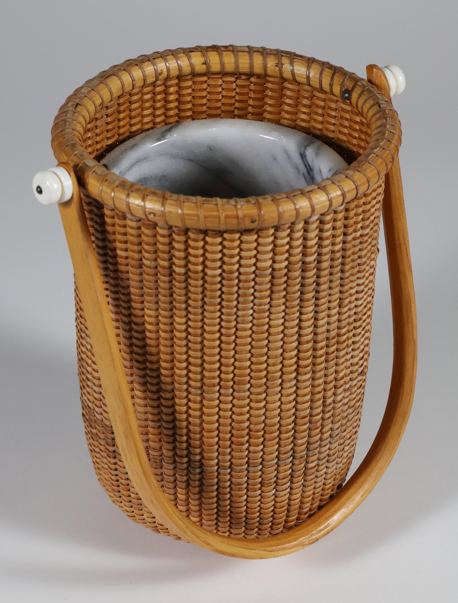 Terry Sylvia Wine Cooler Nantucket Basket, circa 1994: Terry Sylvia Wine Cooler Nantucket Basket, circa 1994, marble liner with swing handle, signed upon the base Terry Sylvia Nantucket Island, 1994 Height 8 in. Diameter 7.25 in. Provenance: The Estate of