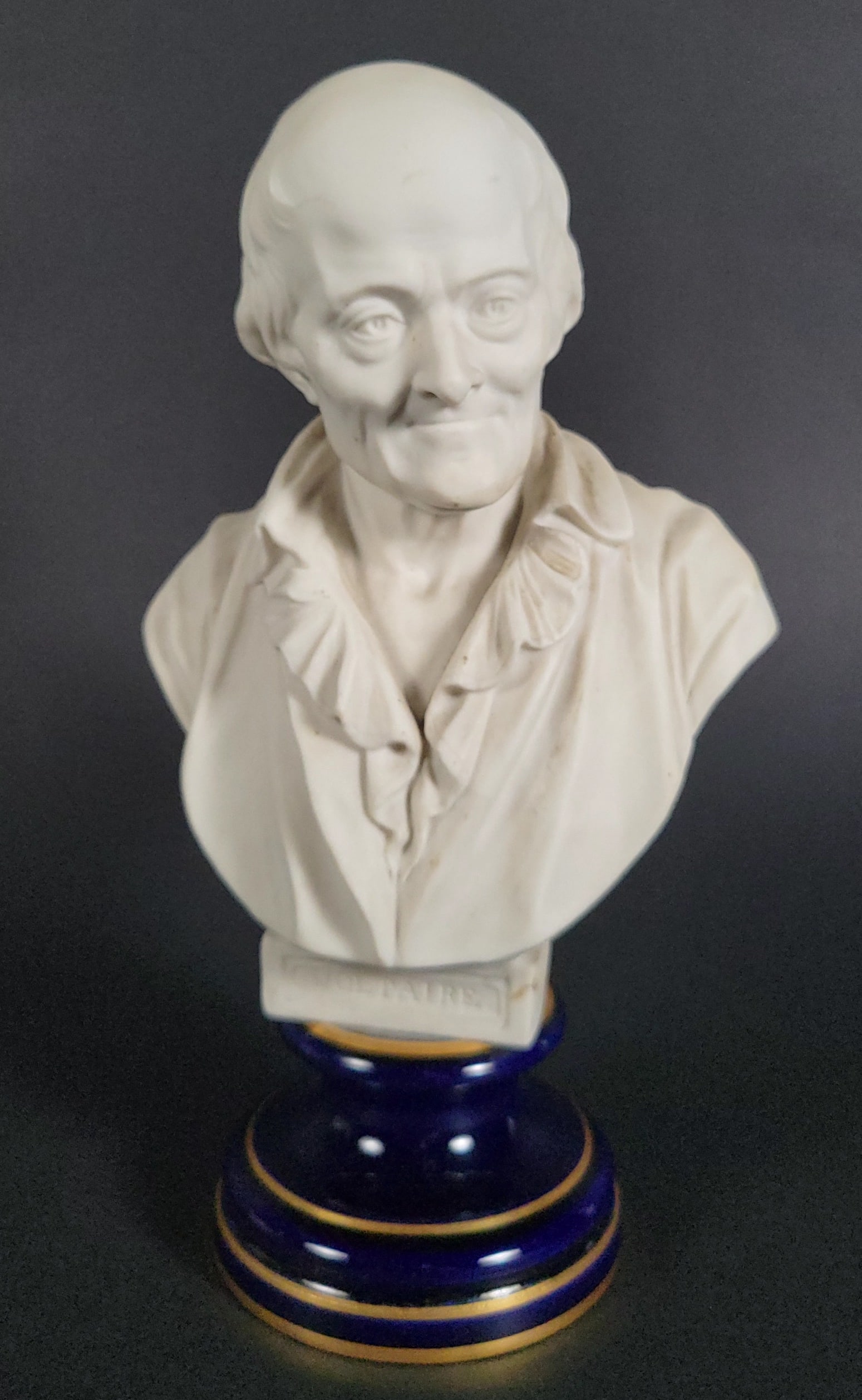 Antique French Porcelain Bust of Voltaire: Antique French Porcelain Bust of Voltaire, with impressed and dated 1923 factory marks and Made in France markings on both bust and underside of plinth. Height 9 in. Width 5 in.