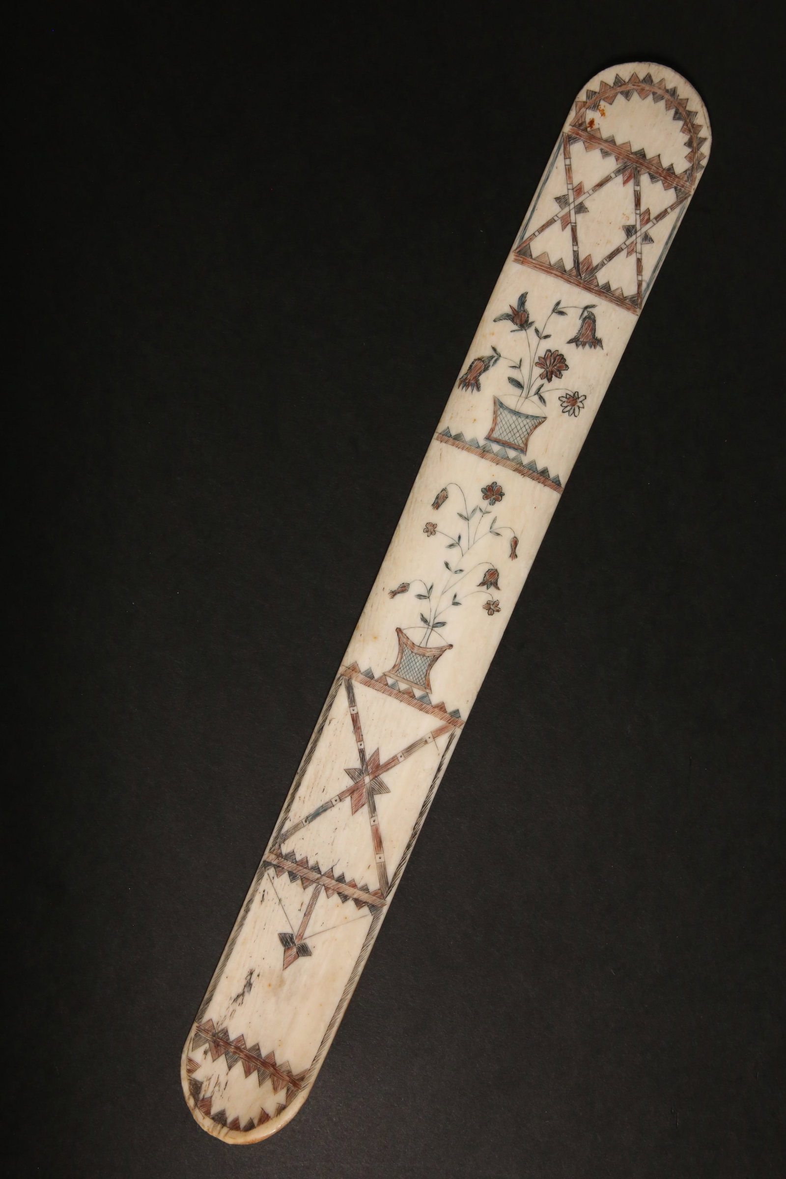 Scrimshaw Antique Whalebone Busk, 19th Century: Scrimshaw Antique Whalebone Busk, 19th Century, polychromed engraved flower filled basket and geometic motifs Length 13.5 in.