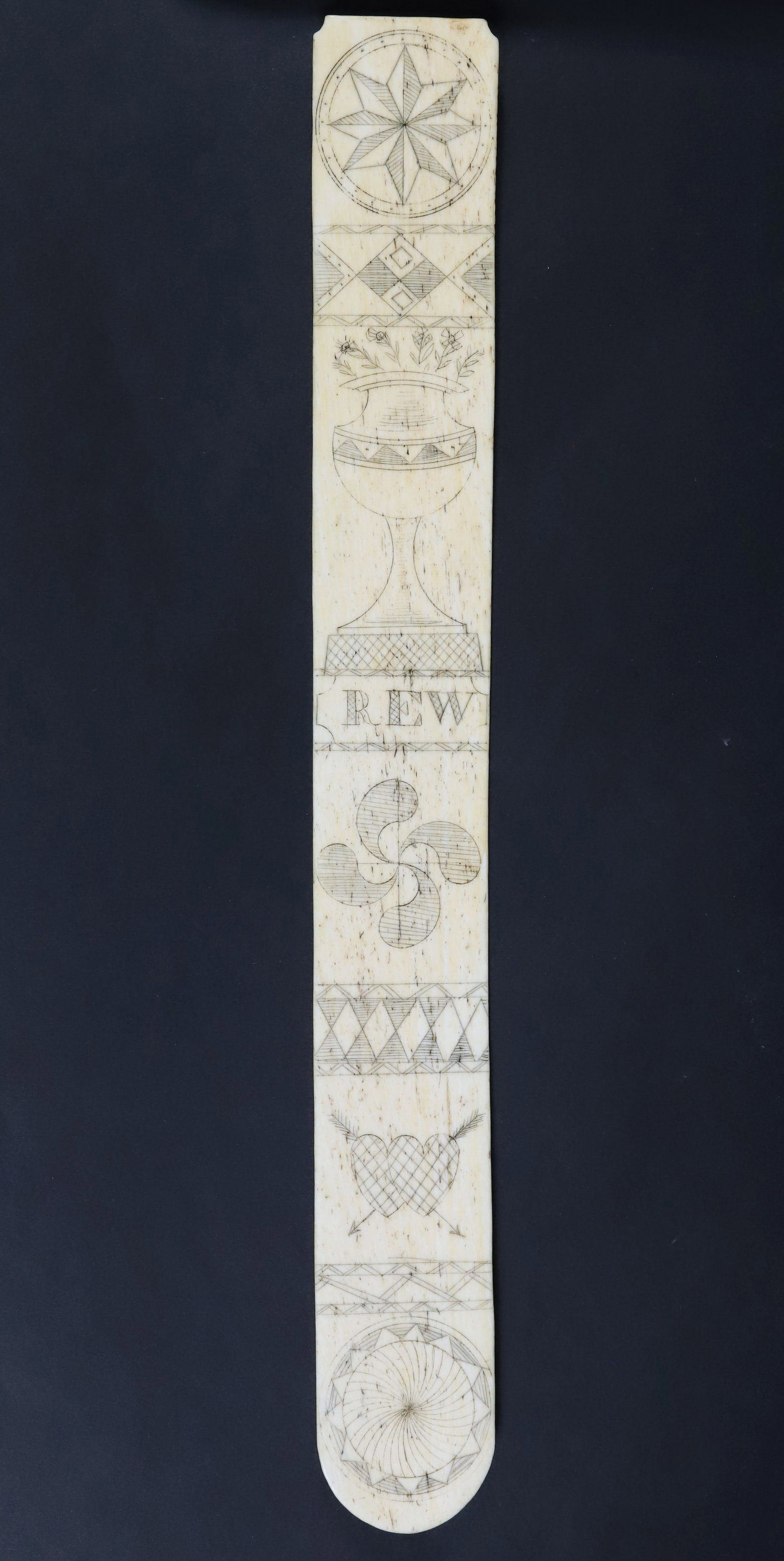 Whaler Made Scrimshaw Whalebone Busk, 19th Century: Whaler Made Scrimshaw Whalebone Busk, 19th Century, engraved "REW", vase of flowers, twin hearts, compass roses and pinwheels Length 14 in. Width 1.5 in.