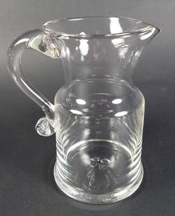 Vintage Simon Pearce Handblown Clear Glass Drink Pitcher: Vintage Simon Pearce Handblown Clear Glass Drink Pitcher, flared upper with scrolled handle, signed upon the base with signature ponitl mark. Height 8 in. Width 4.75 in. Depth 6.5 in.