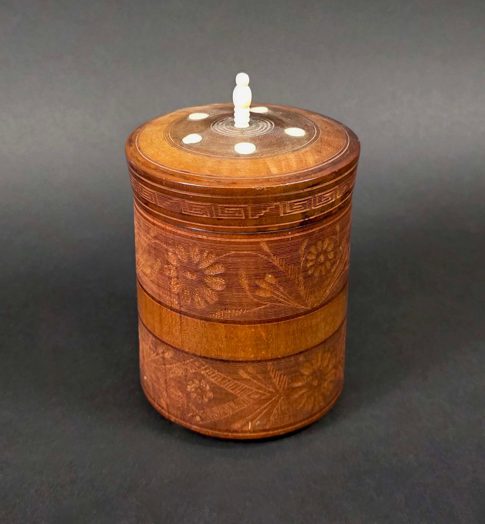 Vintage Carved and Inlaid Circular Cedar Box: Vintage Carved and Inlaid Circular Cedar Box, 20th century, with floral relief carved decoration, bone inlay, feet, and finial. Height 5.5 in. Diameter 3.5 in.