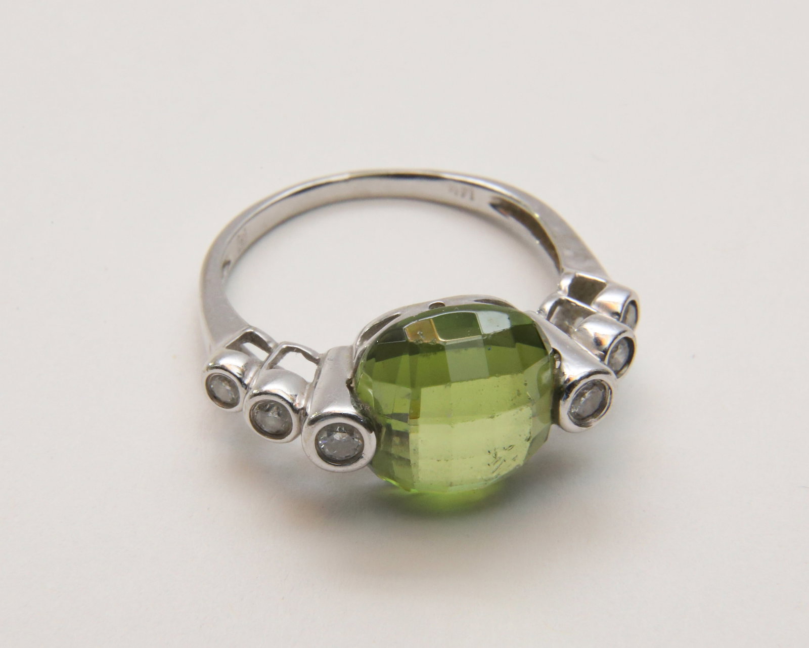 Vintage 14K White Gold Faceted Peridot and Diamond Ladies Cocktail Ring: Vintage 14K White Gold Faceted Peridot and Diamond Ladies Cocktail Ring Size 7, set with 6 small diamonds and faceted peridot Peridot 10mm x 10mm Weight 3.93g Provenance: The Estate of Marguerite G. D