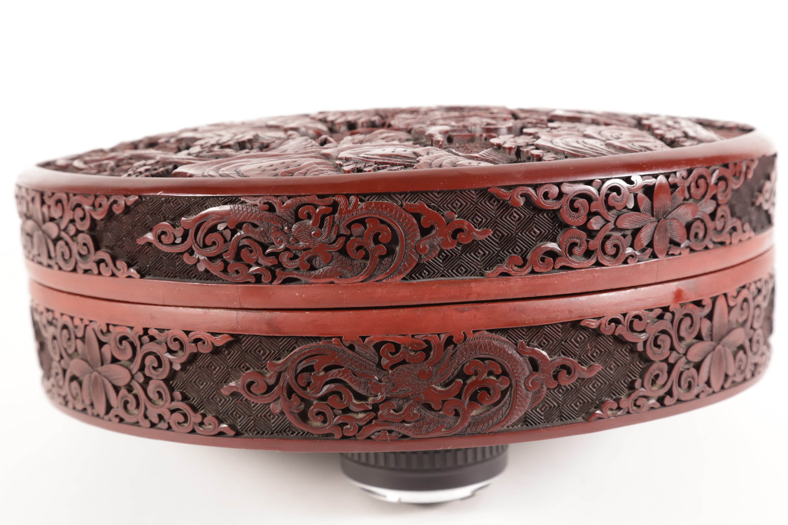 Fine Carved Cinnabar Round Box, 19th Century: Fine Carved Cinnabar Round Box, 19th Century, round form with removable top depicting an active warrior scene with four horsemen and footman and several others behind very thick foliage and trees; the