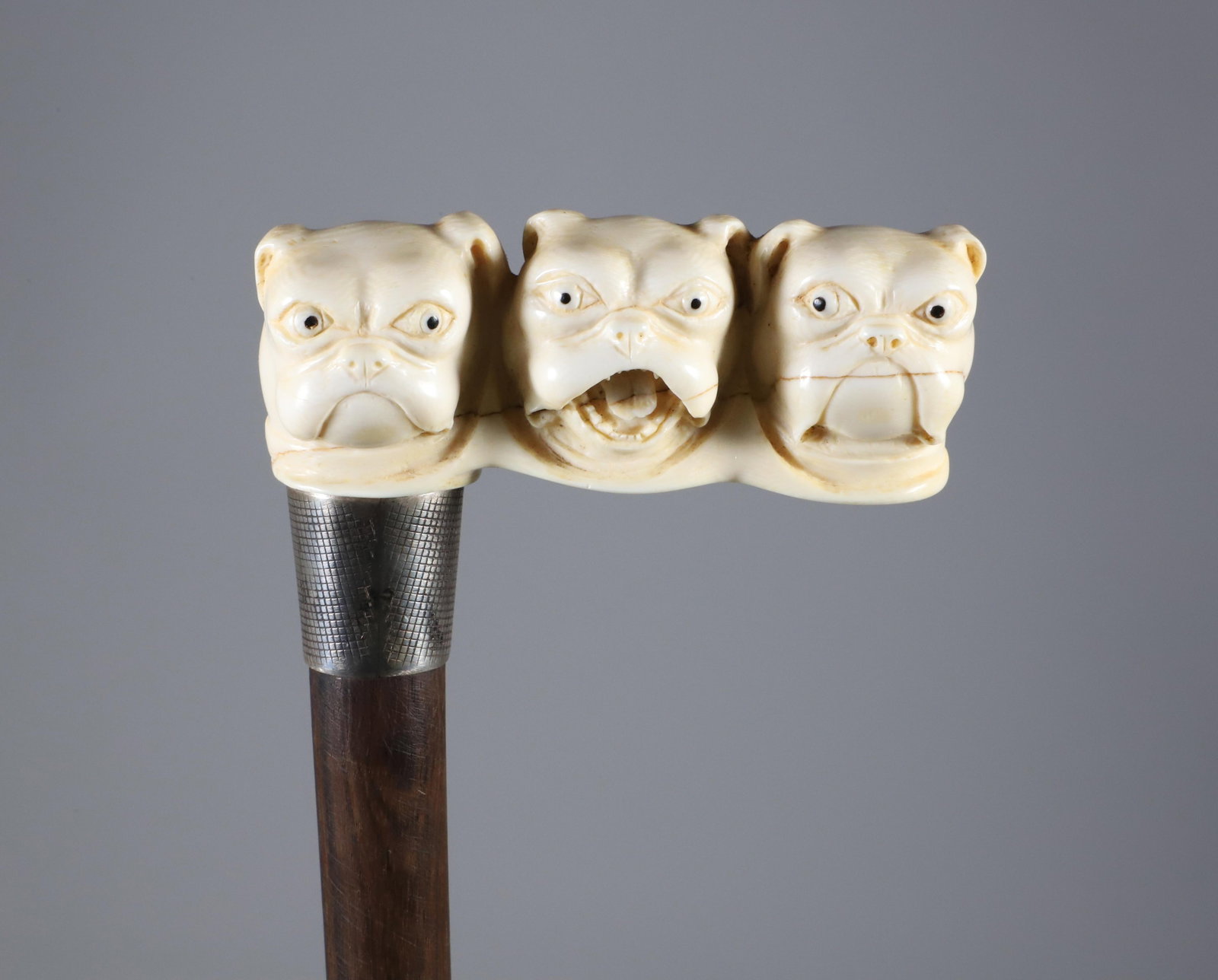 Carved Triple Bull Dog Head Cane, 19th Century: Carved Triple Bull Dog Head Cane, 19th Century, with chased silver collar on wood shaft.**This item is not available for International Delivery. Lengths 36 in. Provenance: Th
