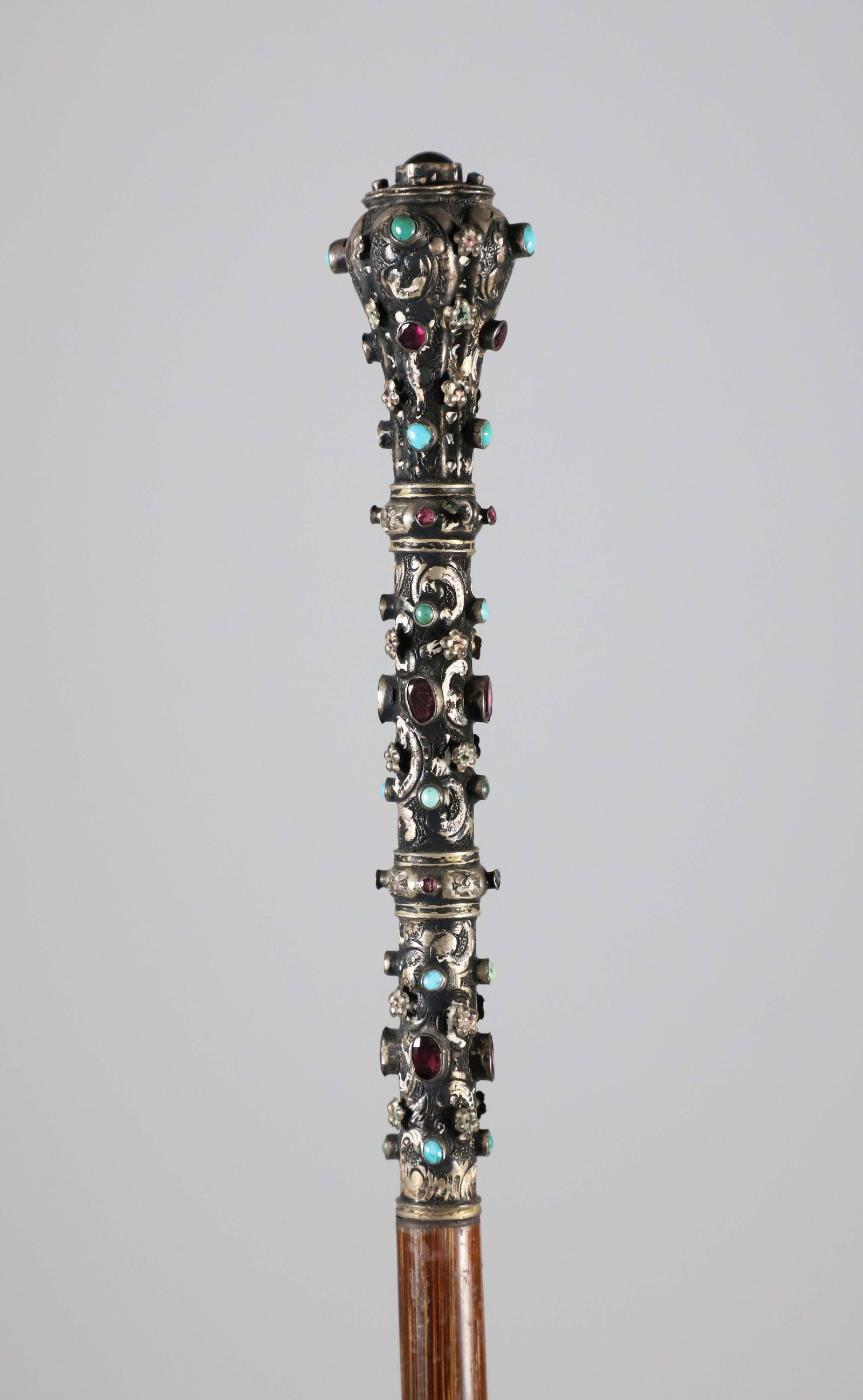 Jeweled Sterling Silver Walking Stick, 19th Century: Jeweled Sterling Silver Walking Stick, 19th Century, set with turquoise, garnet, amethyst stones on a tapering on tapering wood shaft. Length 38 in. Provenance: The Estate of Herbert