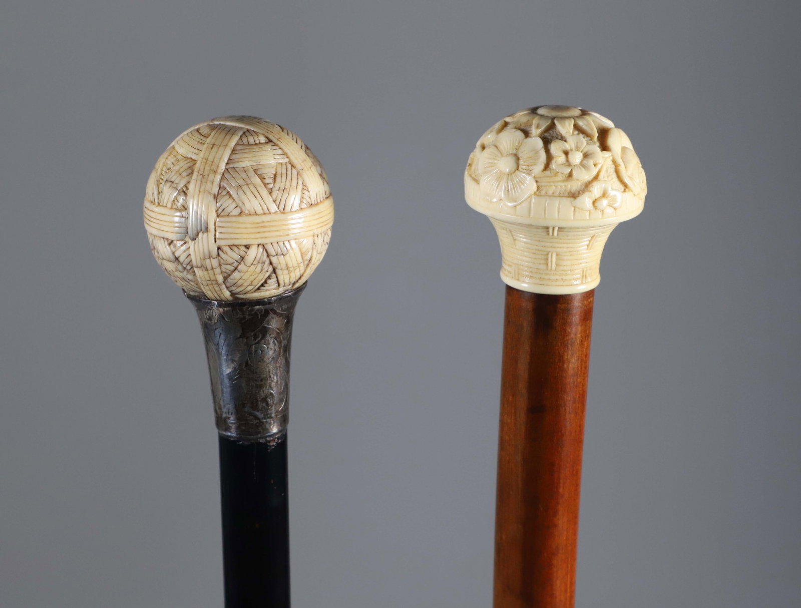 Two Carved Knob Grip Walking Sticks, 19th Century: Two Carved Knob Grip Walking Sticks, 19th Century, the 1st carved as a ball of string with a silver collar, the 2nd a floral mushroom grip, both on wood shafts. **Note: This item is not available for 