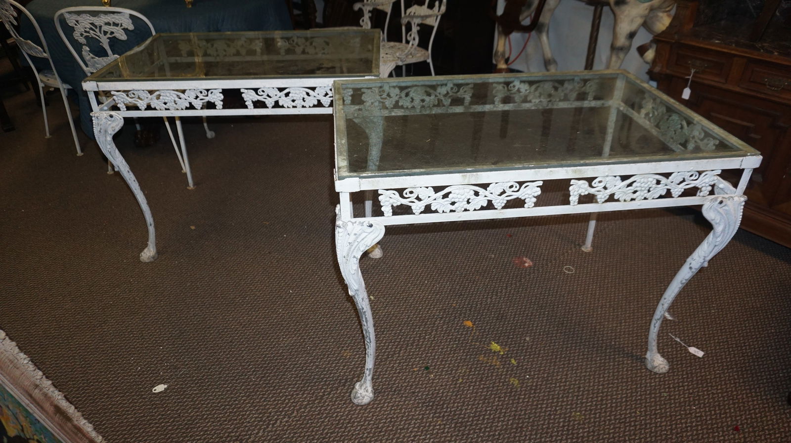 Pair Woodard Grape Vine Console Tables: Pair of Woodard cast aluminum console tables in the Grape Vine pattern with scrolling grape and leaf aprons and glass tops, finished in aged white paint.