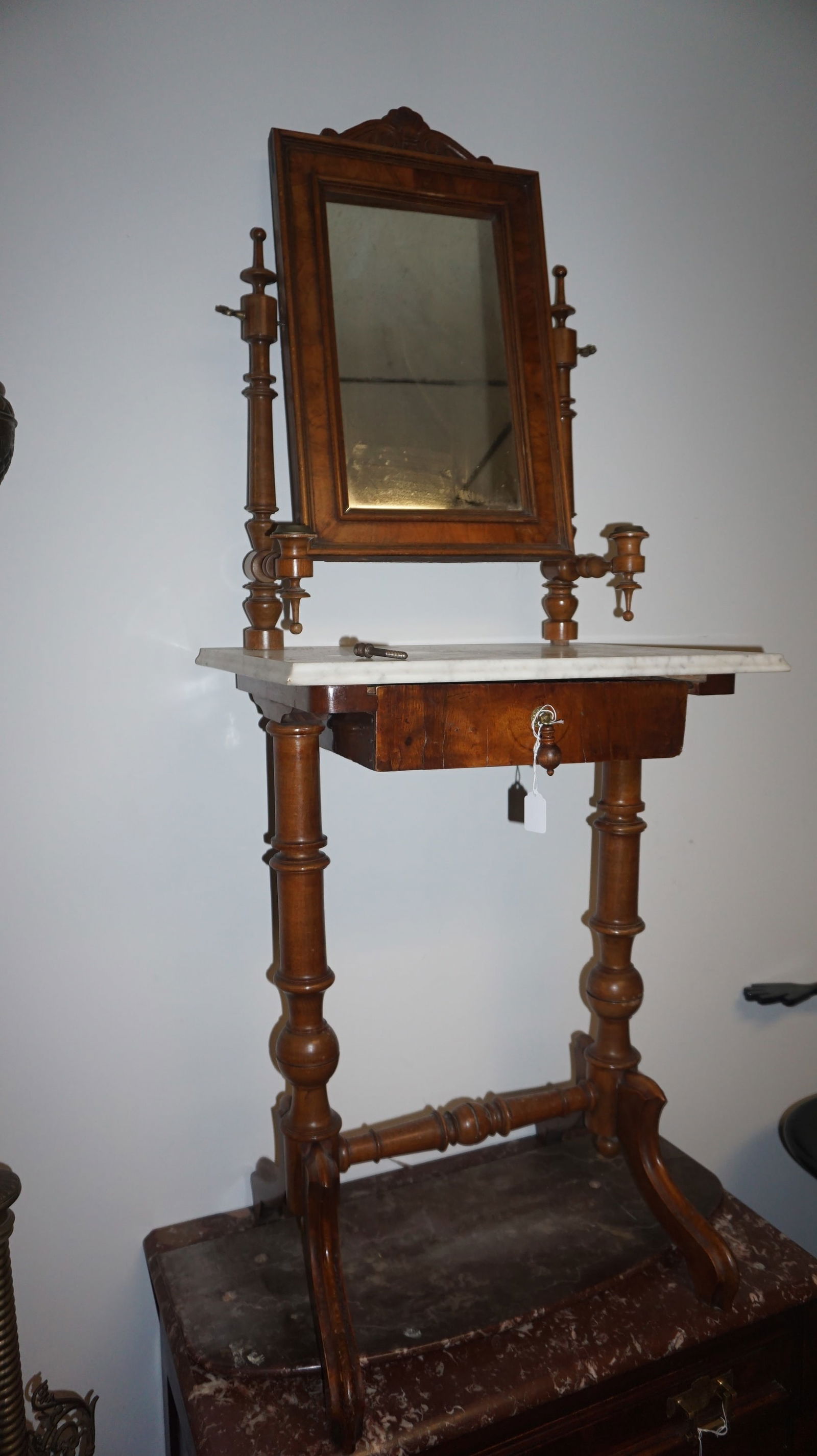 Victorian Eastlake Marble Shaving Stand: Victorian Eastlake walnut shaving stand with white marble top, adjustable framed mirror, turned supports, candle holders, and lower storage drawer.