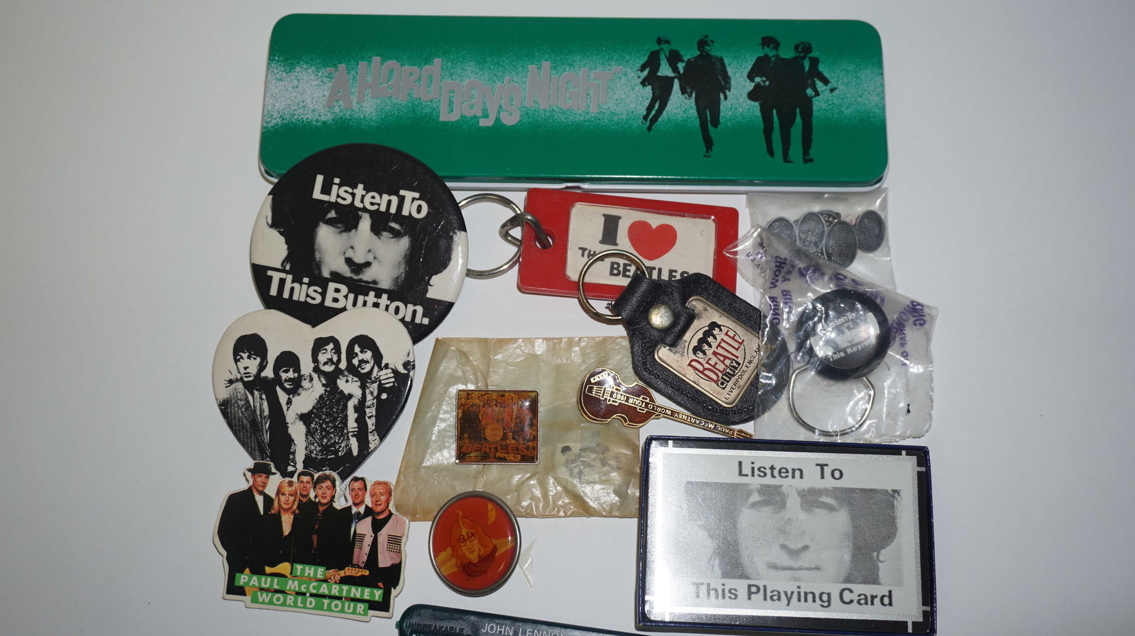 Beatles Misc. Memorabilia Lot: Large mixed lot of Beatles memorabilia including buttons, keychains, small pins, novelty items, tin box, John Lennon “Listen To This Button” piece, heart-shaped Beatles pins, and other fan