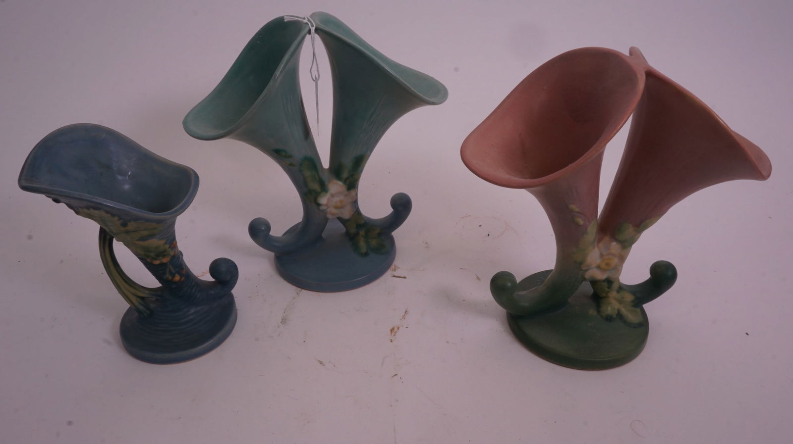 Roseville – 3 Cornucopias 11L5-8/153-6/1165-8: Lot of three Roseville Pottery cornucopia vases in assorted patterns and glazes: 11L5-8, 153-6, and 1165-8.