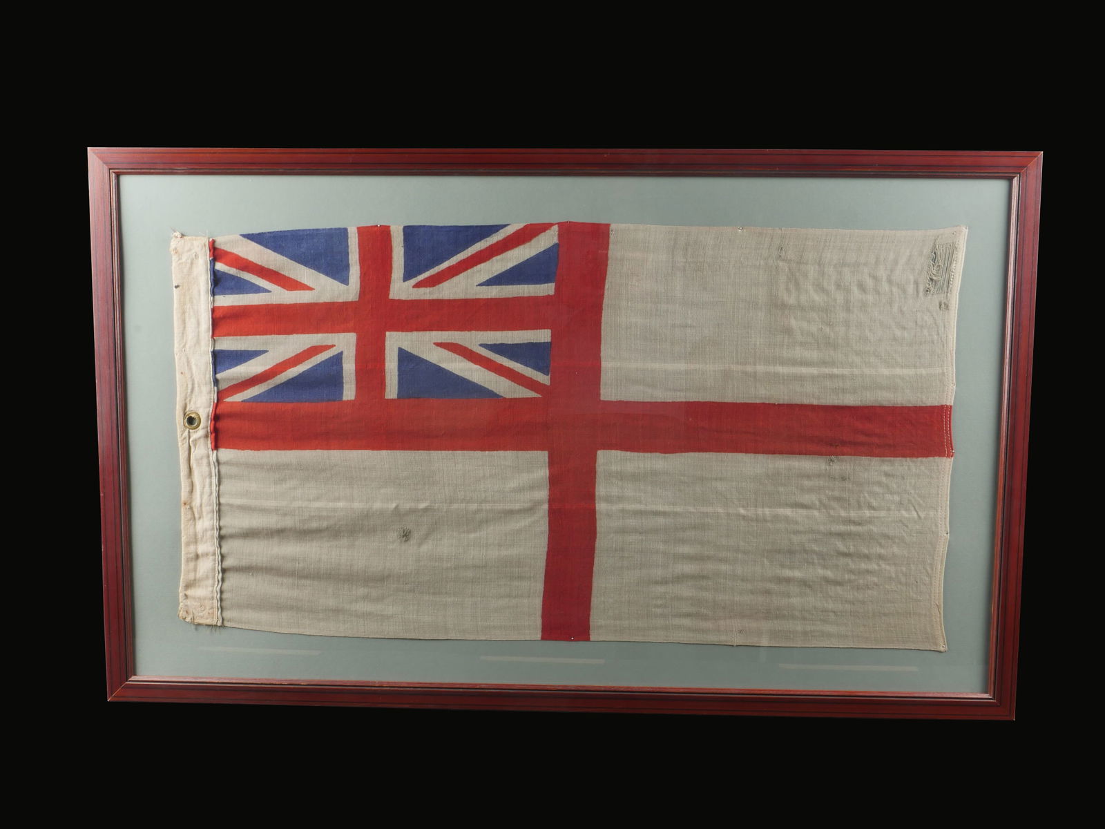 Drapeau du LST 575 britannique de Juno Beach. Flag of the British LST 575 at Juno Beach.: Drapeau du LST 575 britannique. Beau drapeau en tissu coton blanc avec croix rouge et Union Jack au niveau du coin superieur gauche. Un œillet present, sans marquages visibles. Sous cadre moderne, di