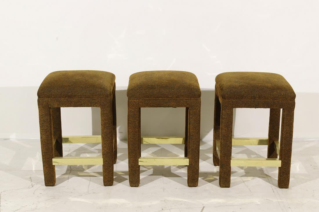 Set of 3 Milo Baughman Style Barstools: Upholstery over wood, brass-clad footrests. 23"h x 16"sq