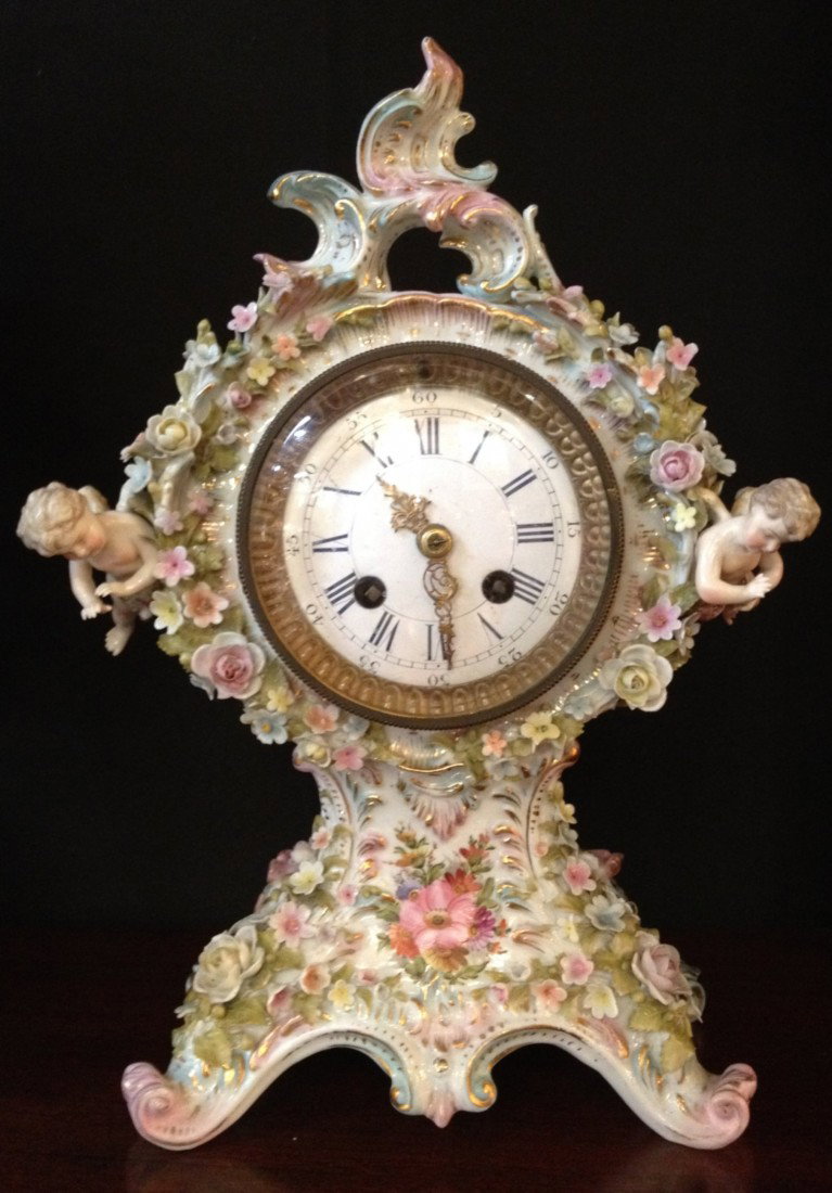 19th C Germany Porcelain Floral Encrusted Clock: 19th Century Germany Porcelain Floral Encrusted Clock with Cherubs. Dimensions: 13" h, 9 w