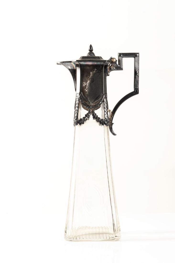 Versatoio con stemma nobiliare, XX secolo: Versatoio con stemma nobiliare in peltro finemente decorato e cristallo molato, XX secolo. Cm 14 x H 34