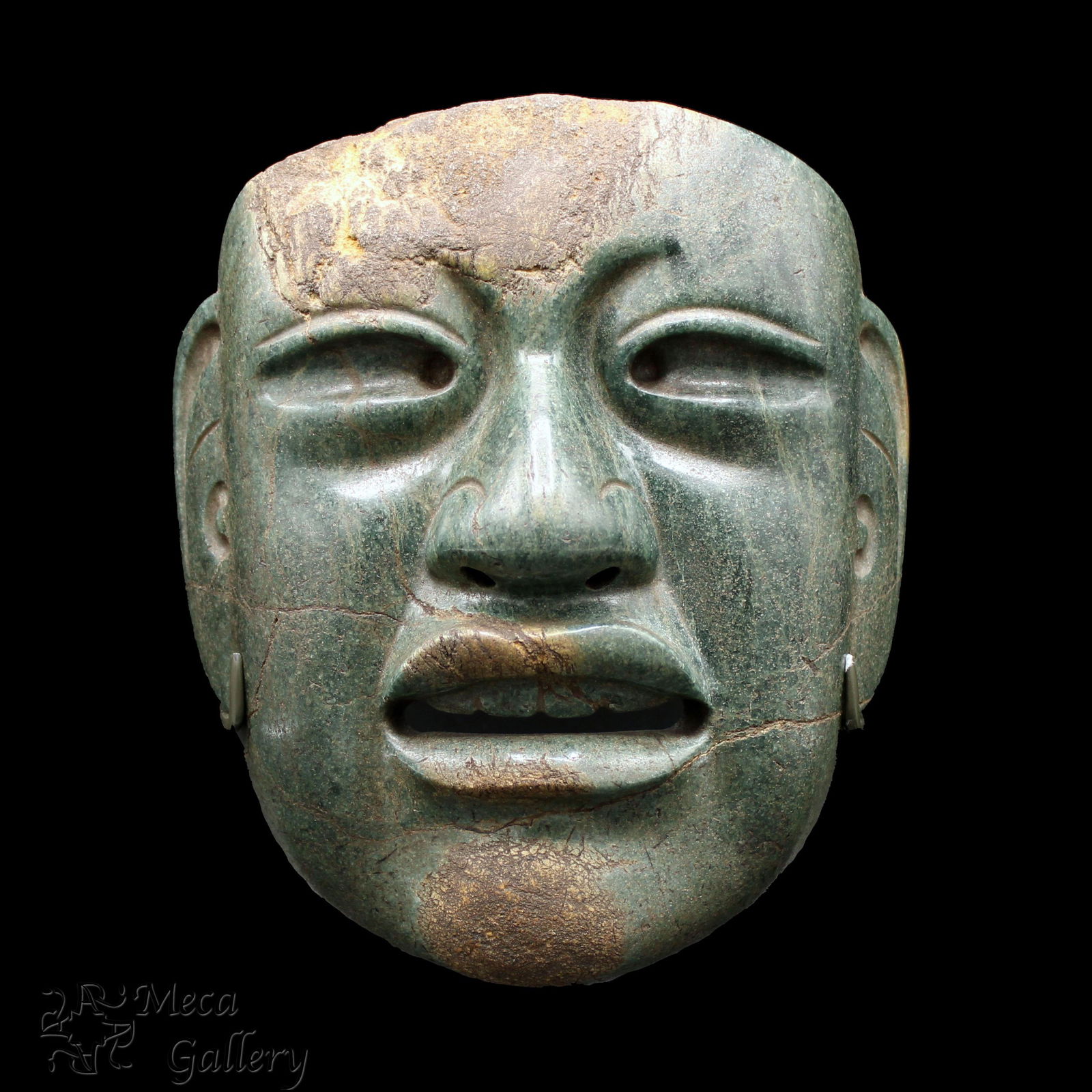 Large Olmec Jade Mask (900-600 BC): Large Olmec Jade Mask (900-600 BC) This impressive Olmec Mask is cut from a brilliant dark green jade. The mask was buried with Olmec mirrors, which caused corrosion to the surface. The use of i